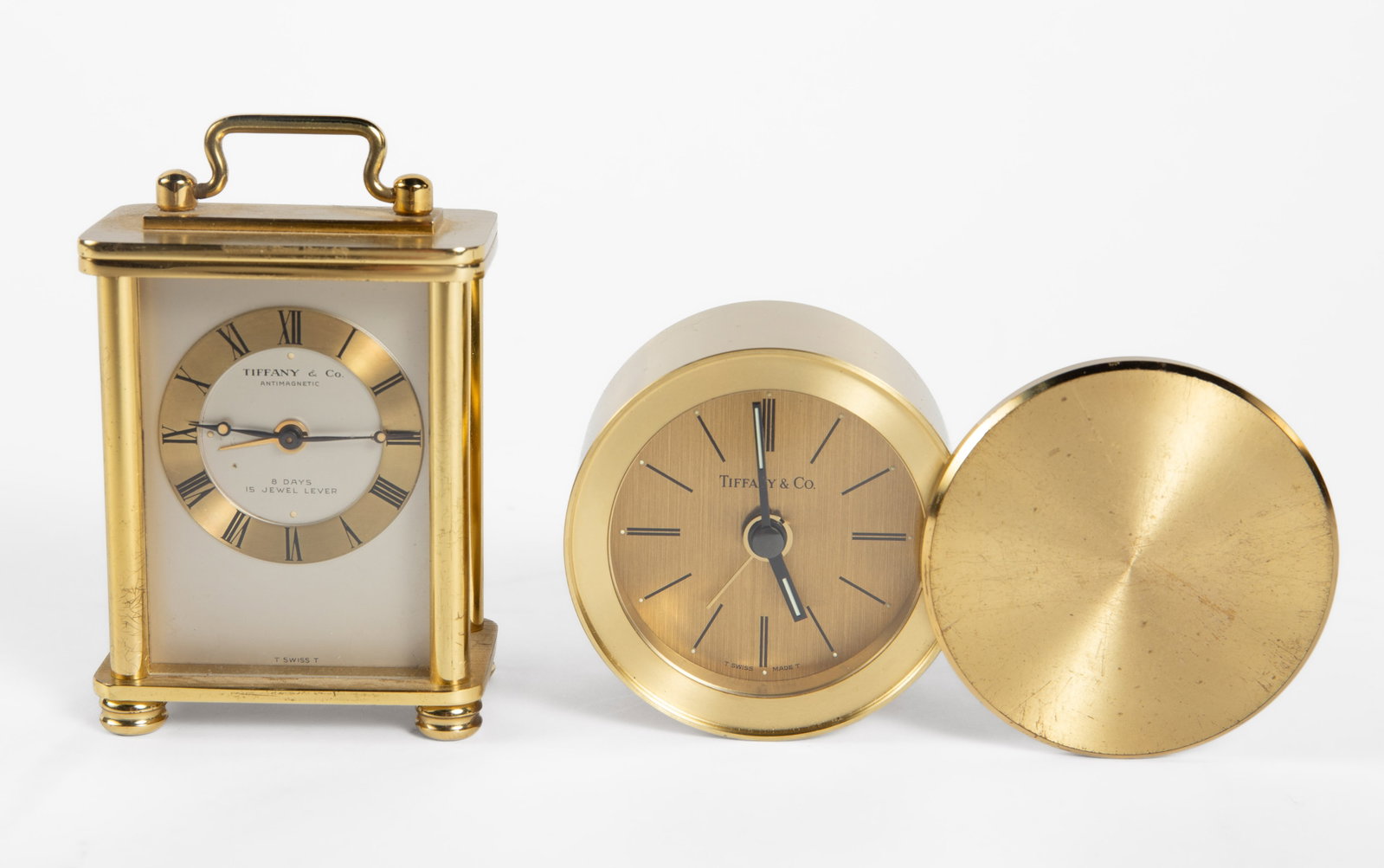 Lot of 2 Tiffany & Co. Brass Travel Clocks.: They are untested, but look to be in overall good cosmetic condition. One clock measures 4 5/8" x 2 1/2" x 1 5/8". The other measures 2 3/8" x 1 3/8" x 3 1/2". In-house shipping is available. To recei