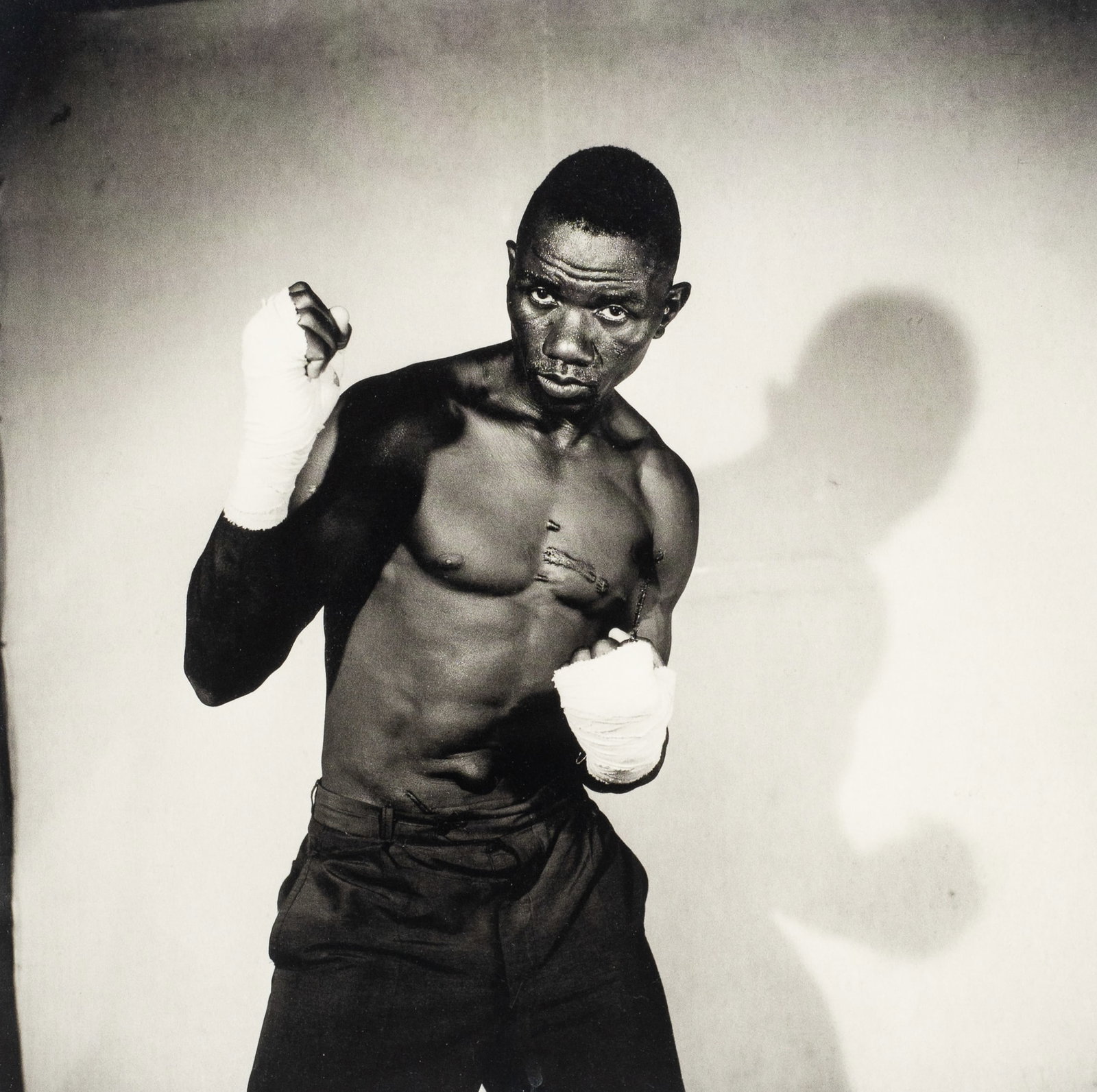 Boxer, Malick Sidibe Framed Photolithograph.: This lot contains a black and white Malick Sidibe (Malian, 1935-2016) photolithograph titled "Boxer", 1966. Paperwork/Provenance: Attached en verso is a label from TIvoli Art Gallery. Condition: No