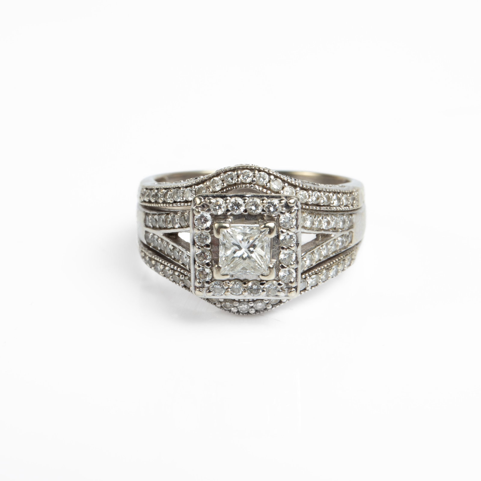 14K White Gold Pave & Princess Cut Diamond Ring.: The ring is marked 14K UD inside the band. It features a central princess cut diamond, which measures 4mm x 4mm. The central diamond is surrounded by a square halo of small round-cut diamonds, and the
