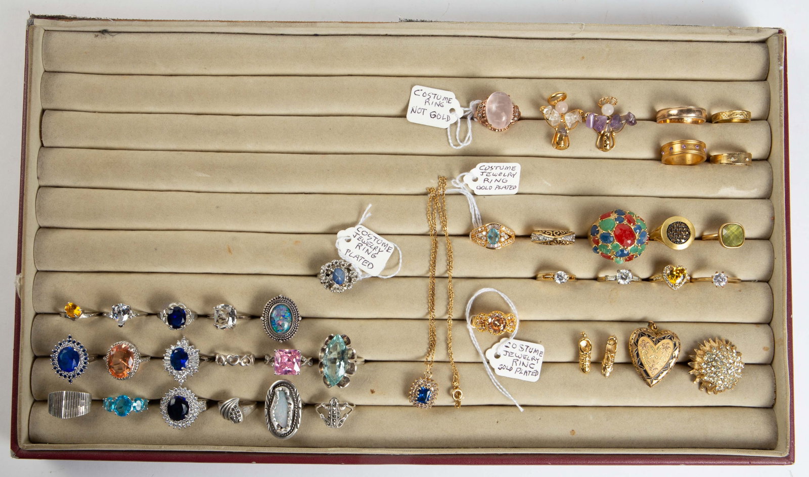 Lot of Mostly Rings Including 17 Sterling & Stones: The lot contains 40 pieces of jewelry. There is a pendant necklace, 2 angel brooches with stones, 2 tennis shoe charms, an antique 12K gold filled heart locket, and 34 rings. Seventeen of the rings ar
