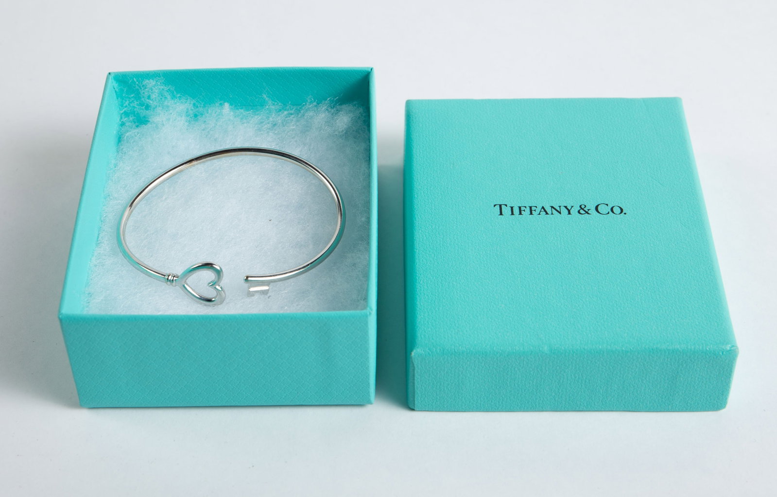 Tiffany & Co. 18K Gold Heart Key Cuff Bracelet.: The white gold bracelet is marked AU 750 Italy T & Co. behind the heart. It measures 2 1/8" across the inside. It comes with the original box. It weighs 4.3 Pennyweight, or 6.7 Grams. There are some s