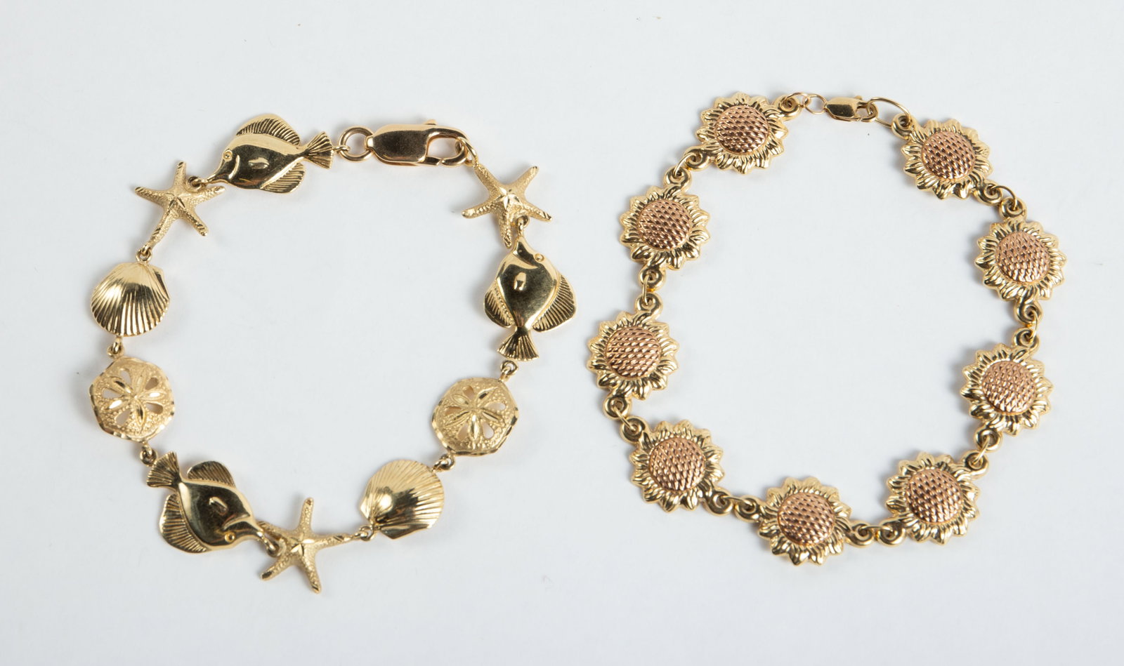 Lot of 10K and 14K Gold Bracelets.: The lot contains 2 link bracelets. There is a two tone piece with Sunflower style links, which is marked 10K on the clasp. It measures 7 7/8" long and 14mm wide. It weighs 4 Pennyweight, or 6.3 Grams.