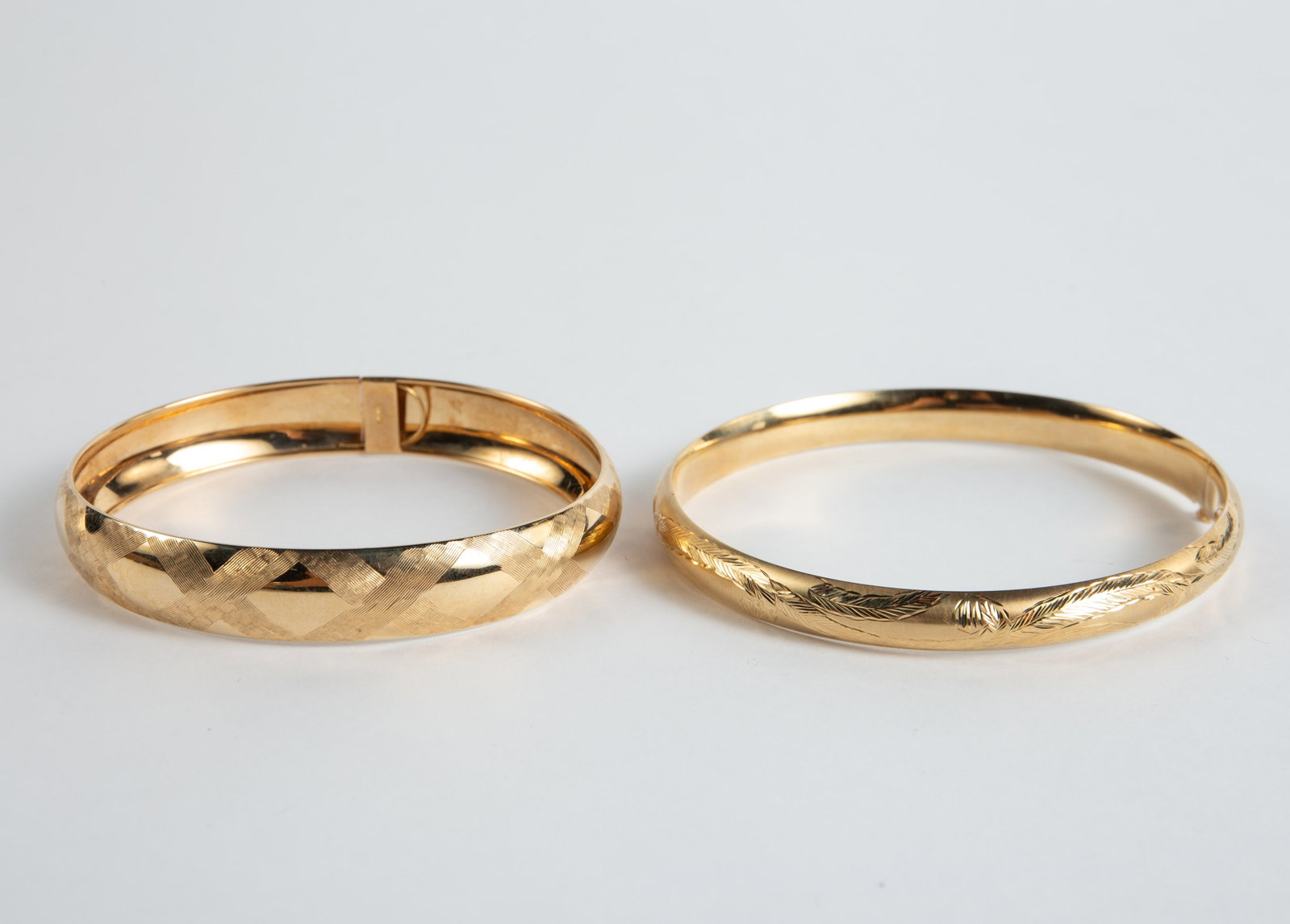 Two 14K Yellow Gold Etched Cuff Bracelets.: The lot contains 2 cuff bracelets. The largest is marked Ma on the clasp. It appears to be unmarked for gold, but tested appropriately for 14K. It measures 2 3/4" across the inside and 8mm wide. The n