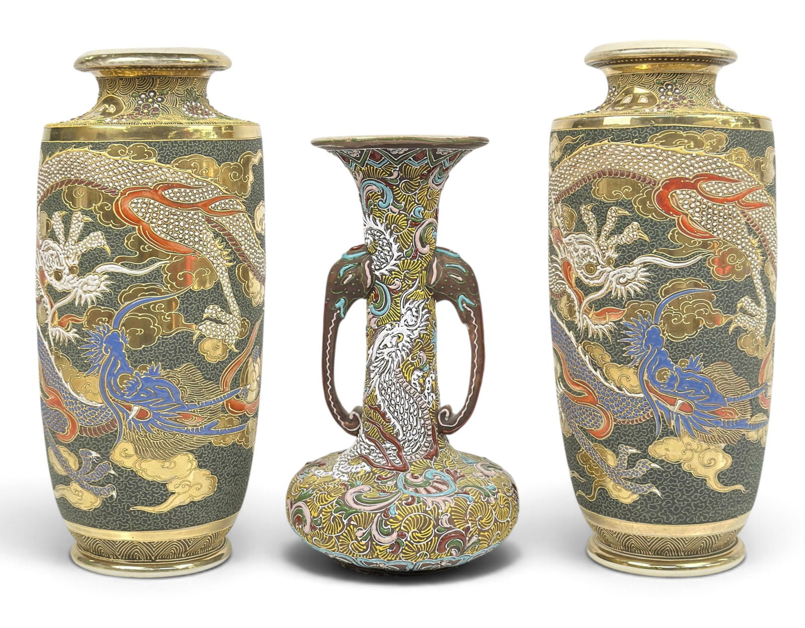 3 Antique Japanese Satsuma Style Moriage Vases: The lot contains 3 Japanese Satsuma vases with moriage decorations. The smallest piece has two elephant trunk handles, and a white dragon decoration amongst ornate patterns. The pair of larger vases, 