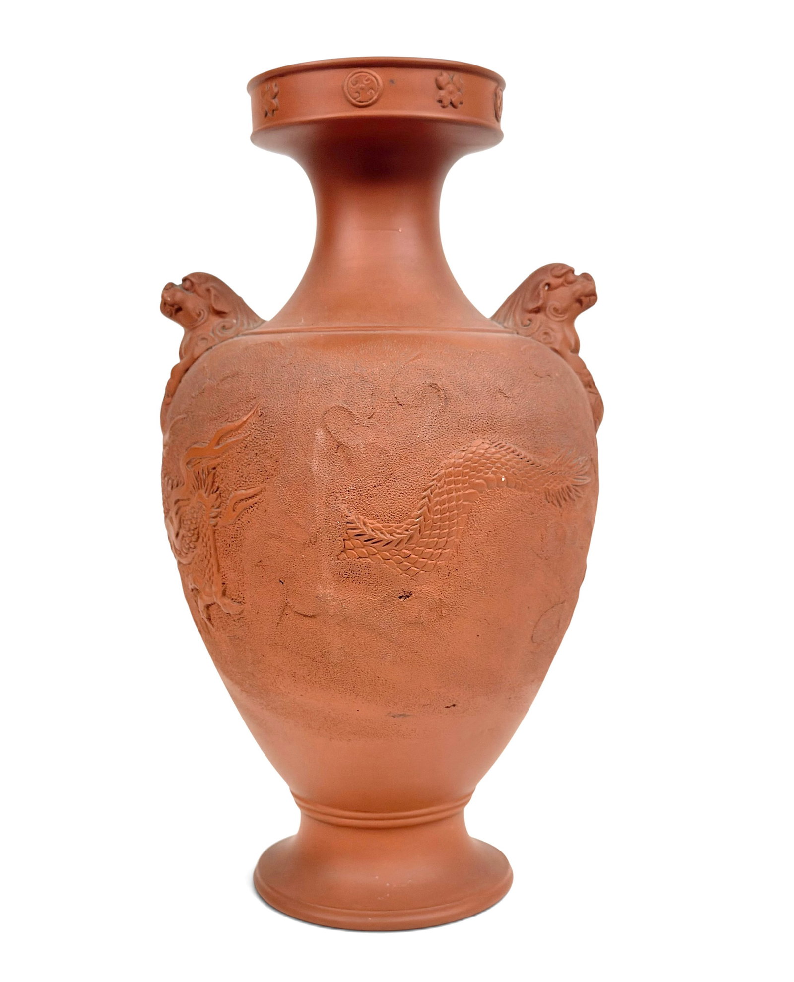 Antique Japanese Terracotta Vase.: The vase features two foo dog handles, and a relief dragon figure intermittently disappearing through the clouds. It measures 12 1/8" tall and 6 3/4" in maximum diameter. There are a few stains on