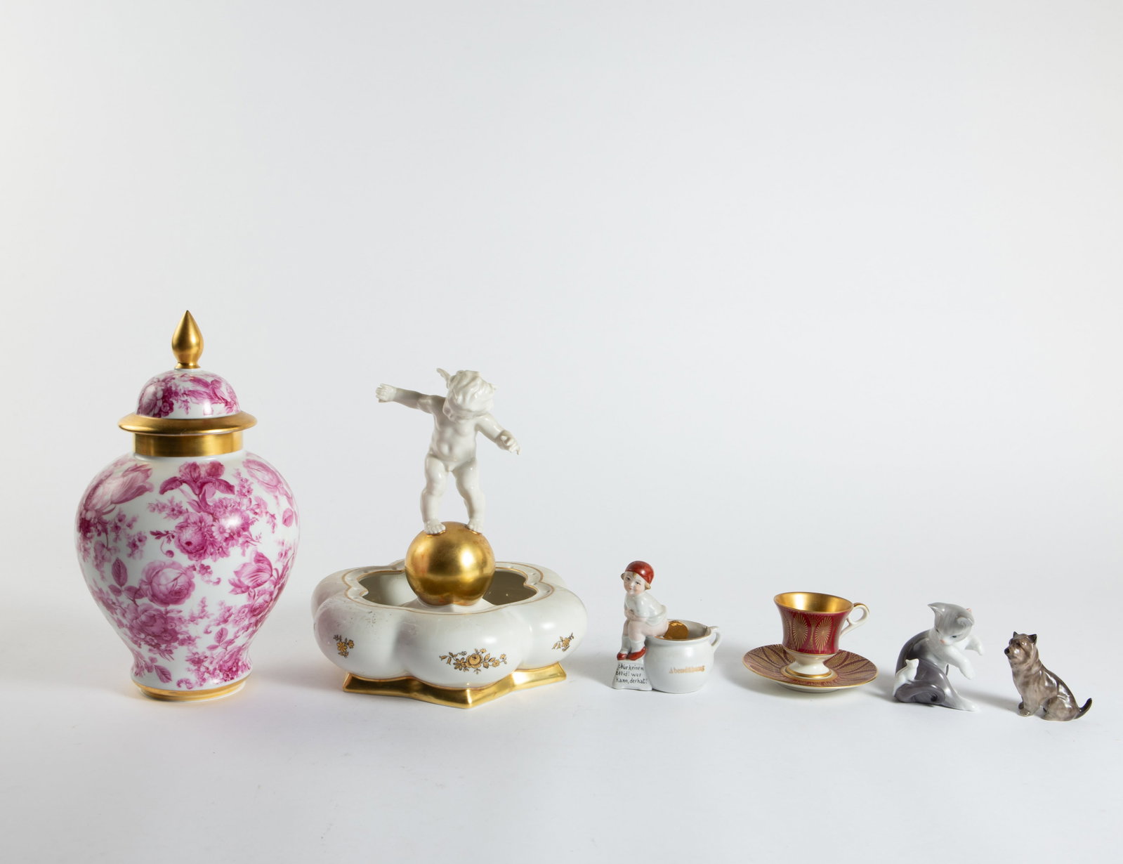 Lot: Hutschenreuther, Lladro, Royal Doulton, etc.: This lot includes a two-piece Hutschenreuther cherub flower frog centerpiece, a Schumann lidded ginger jar with pink flowers, a Lladro cat and mouse figure, a Royal Doulton terrier figurine, and more.
