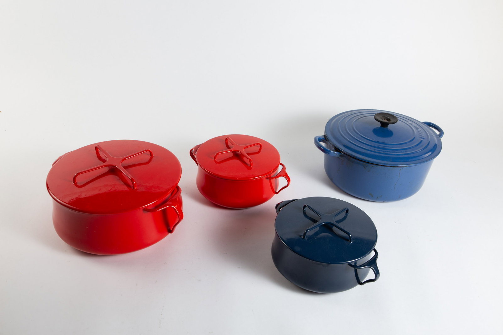 Lot of Le Creuset and Dansk Enameled Cookware.: This lot includes a a blue cast iron Le Creuset Dutch oven (needs cleaning) and three Dansk enameled blue and red pots. The largest item in the lot measures 13 1/2" x 11" x 7 3/8". The smallest item m