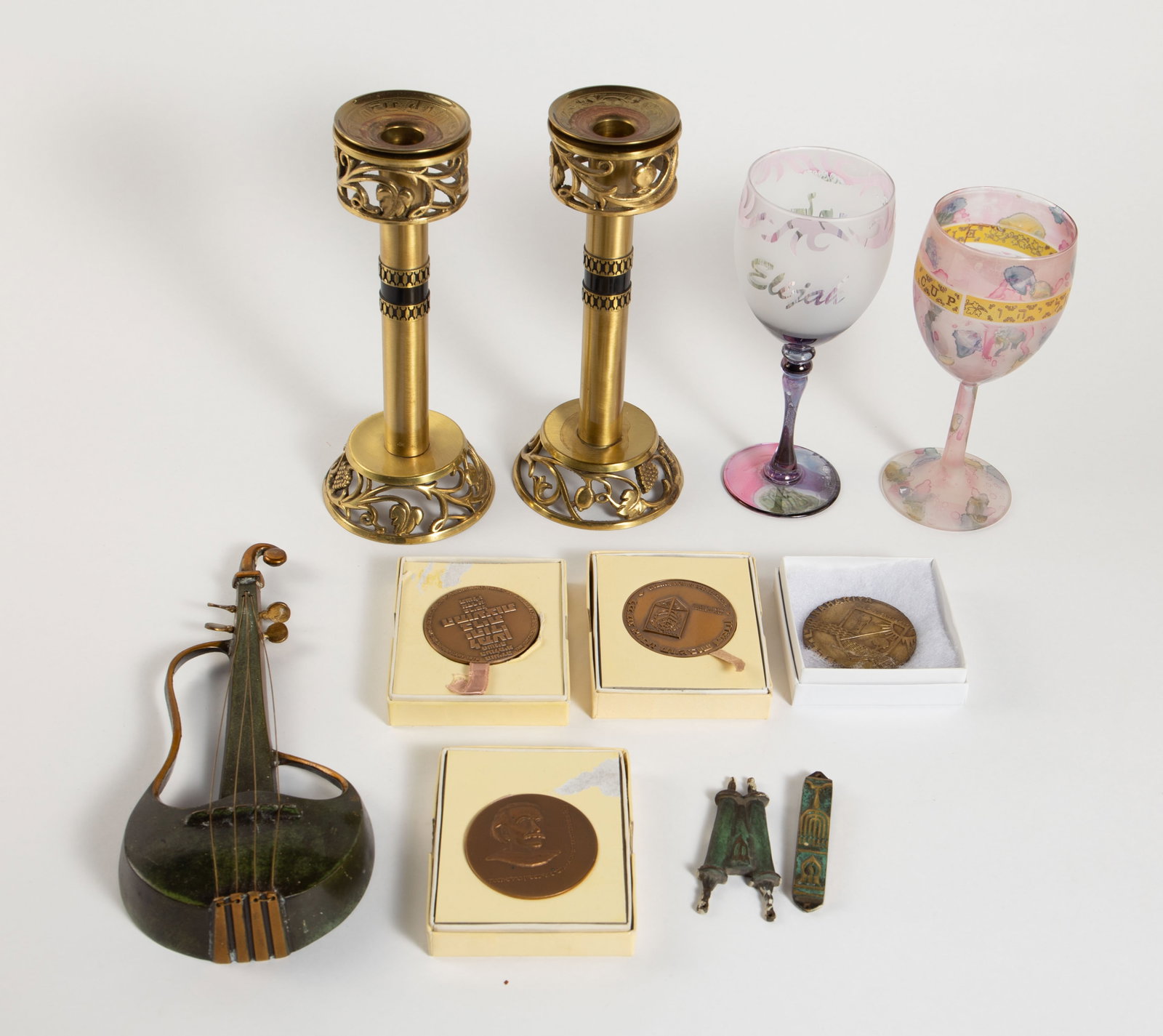 Lot of Assorted Judaica Items- Candlesticks, etc.: Overall, this lot looks to be in good condition. The largest item measures 3 5/8" x 3 5/8" x 9 1/8". The smallest item measures 3 3/8" x 1/2" x 1/4". In-house shipping is available. To receive the