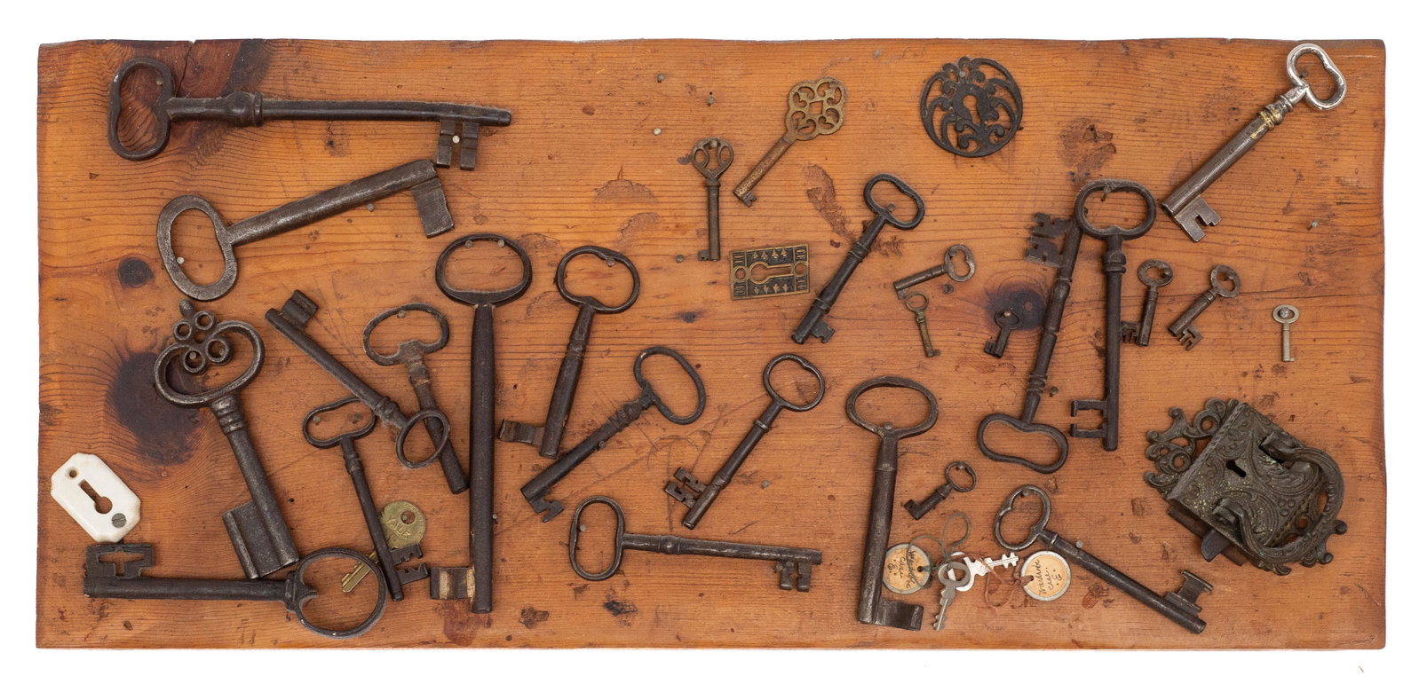Lot of Antique Keys w/ Wood Hanging Board.: An ornate lock and a few ornate plates are also included. Some of the keys are quite large. The board measures 25 3/8" x 11 1/2" x 1". The smallest item measures 1 3/8" x 3/8" x 1/8". In-house shippin