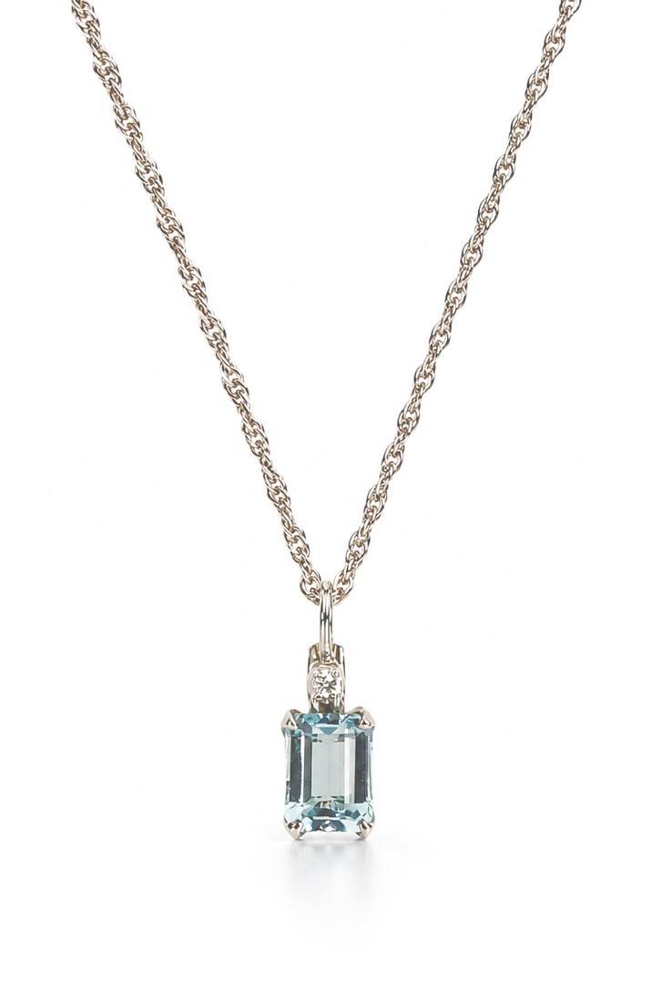14K White Gold and Aquamarine Necklace.: The necklace features a small pendant with a baguette cut light blue stone, likely an aquamarine, and a small round clear stone. The clasp is marked 14KT. The rope chain measures 14" long, and the pen