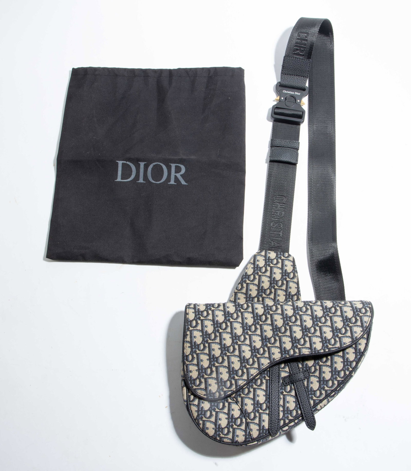 Christian Dior Oblique Saddle Cross Body Bag.: The unisex designer bag is branded Dior on the zipper and strap hardware, as well as on the inside, along with Made in Italy. The inside also has a leather serial number tag. The wide adjustable strap