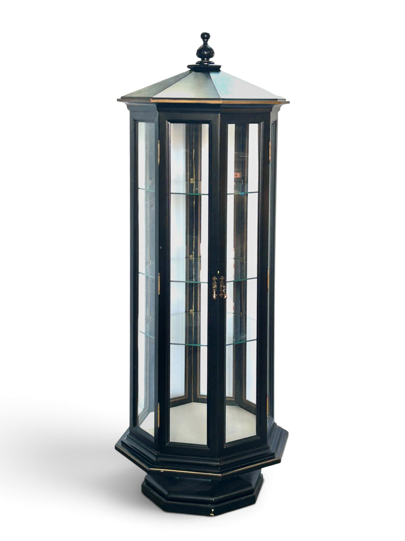 Illuminated Octagonal Curio Display Cabinet.: The cabinet has 8 glass sides, 2 doors with brass pulls, 3 beveled glass shelves, a white fabric wrapped bottom, a pedestal style base, and a pointed top with a turned wood finial. It is painted