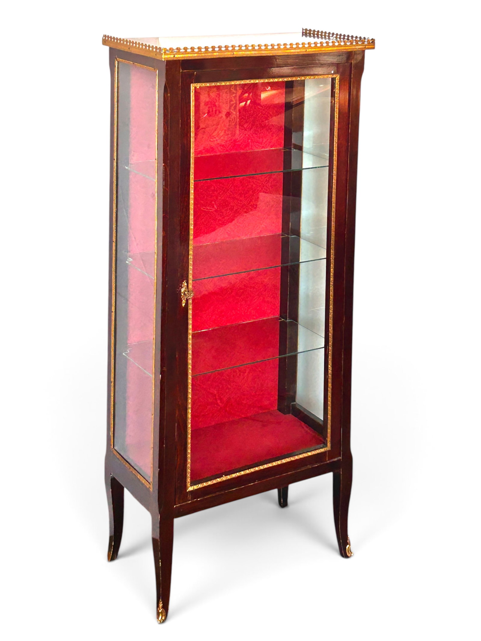 Louis XV Style Showcase, Vitrine, or Curio Cabinet: The vintage piece has 3 glass sides with brass borders, a pierced brass gallery top, 3 glass shelves, a textured red fabric wrapped back, curved legs with brass appliques, and a lock and key. It measu