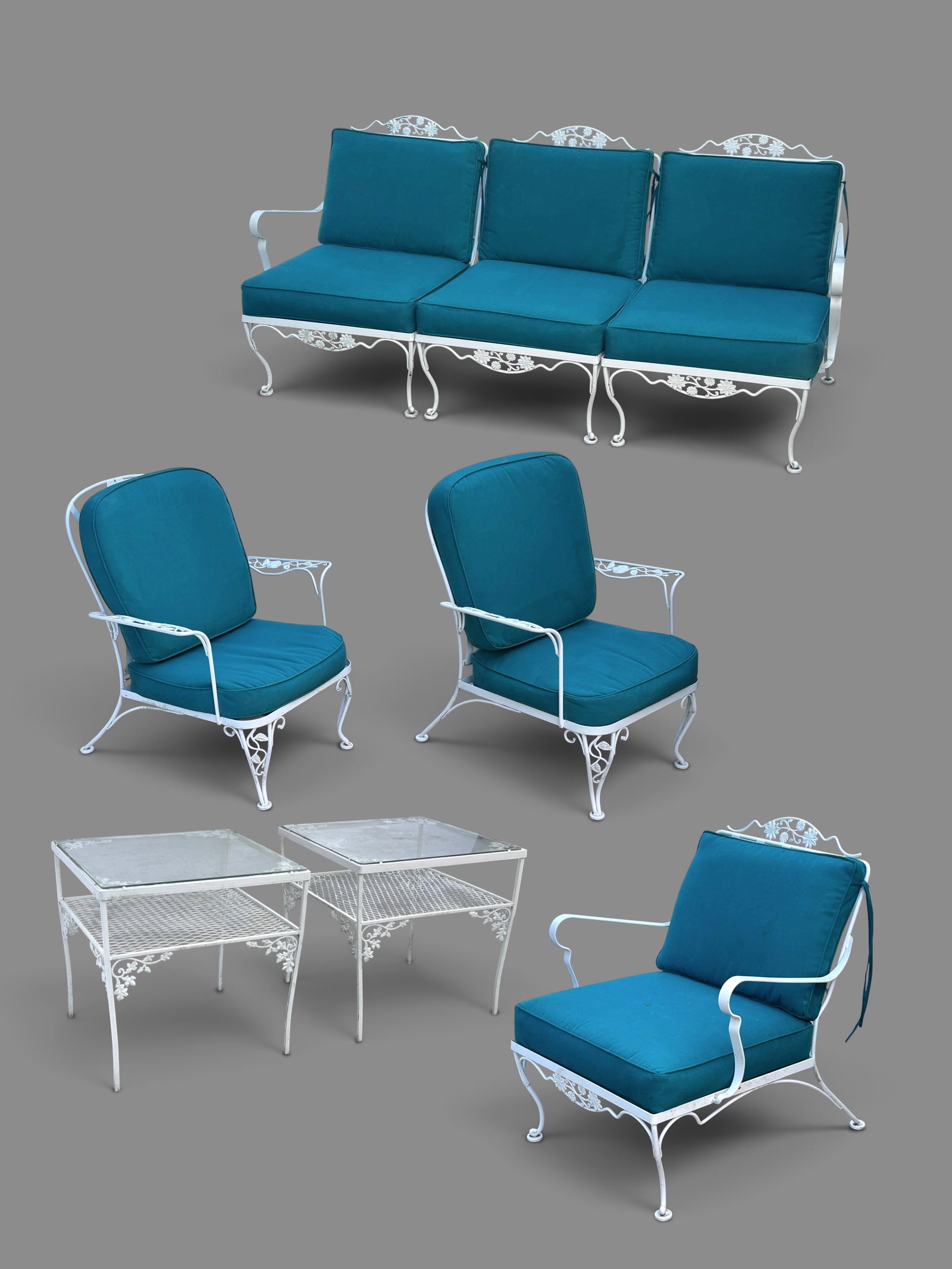 6 Pc. White Wrought Metal Outdoor Patio Set.: The vintage patio set features flower and foliage designs. The lot contains a 3 seat sofa, 2 armchairs, a deep lounger chair, and two 2-tier glass top side tables. The items have removable turquoise v