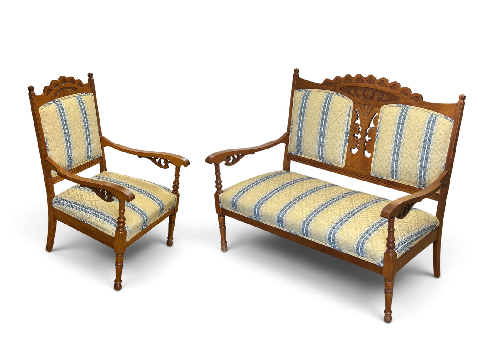 Carved Eastlake Victorian Settee & Armchair Set.: Both pieces have blue and yellow striped upholstery with a floral damask pattern. The arms have pierced carvings, as does the settee on the back. Both look to be in good condition. The settee measures