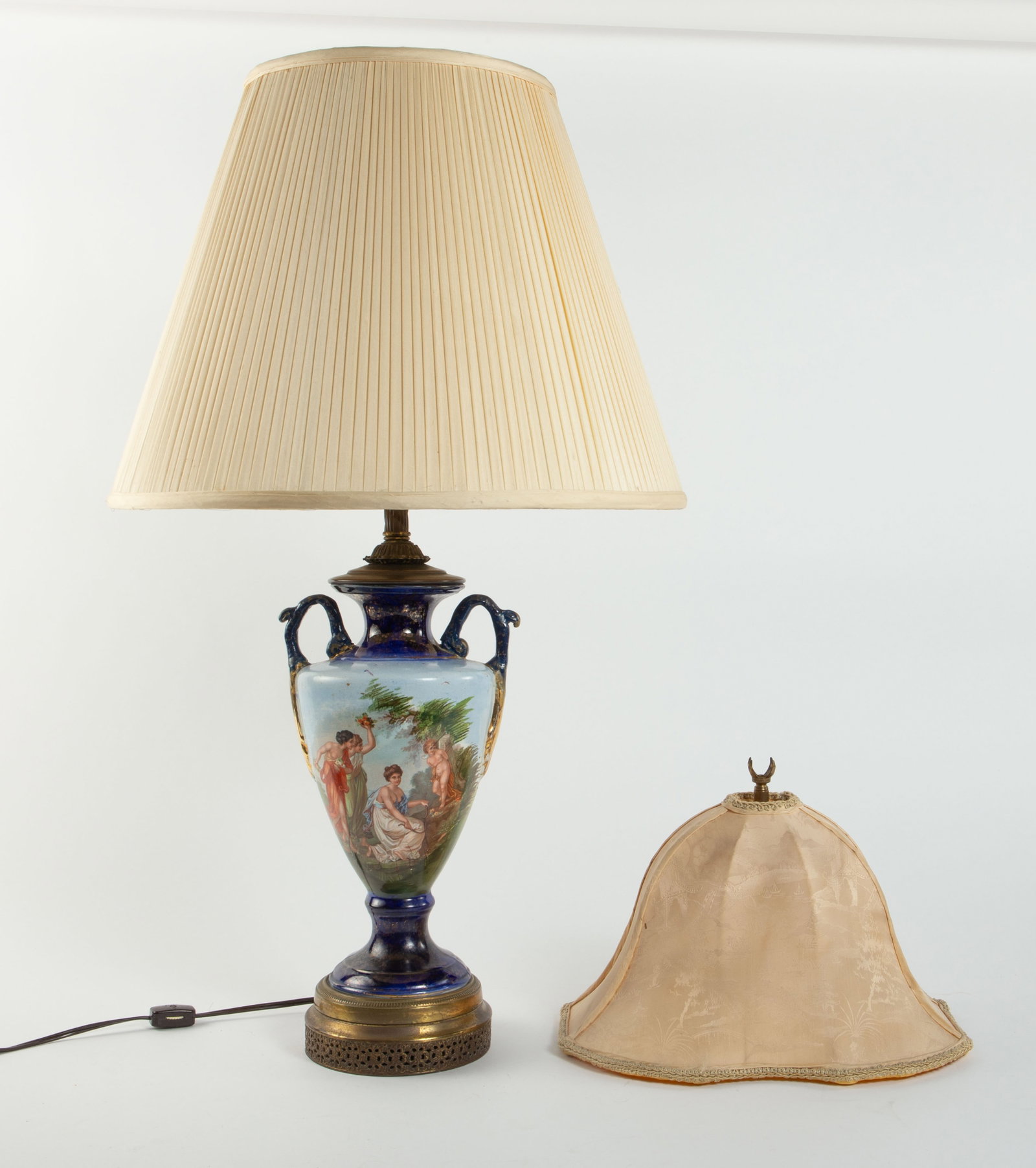 Porcelain Urn Lamp w/ Mythological Scenes.: It has some signs of surface wear. It has a fabric lamp shade, and comes with a second smaller lamp shade. The lamp itself measures 7 1/4" x 6 7/8" x 29", with the shade measuring 17 1/4" x 17 1/4" x 
