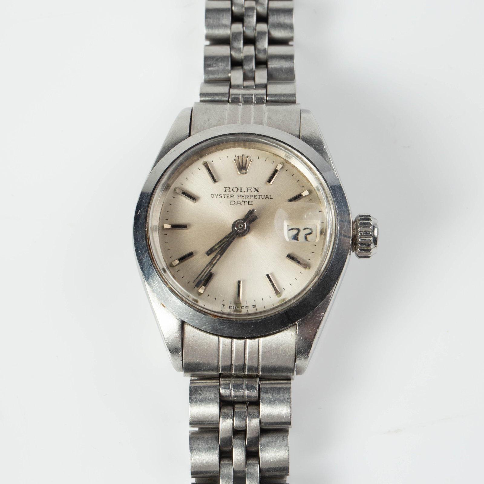 Womens' Rolex SS Oyster Perpetual Date Watch, 1972: The vintage stainless steel watch is serial #30802XX and model #6916. It comes with the original link band. It ticks. The case measures 1", or 25mm in diameter. There are some scratches on the piece.
