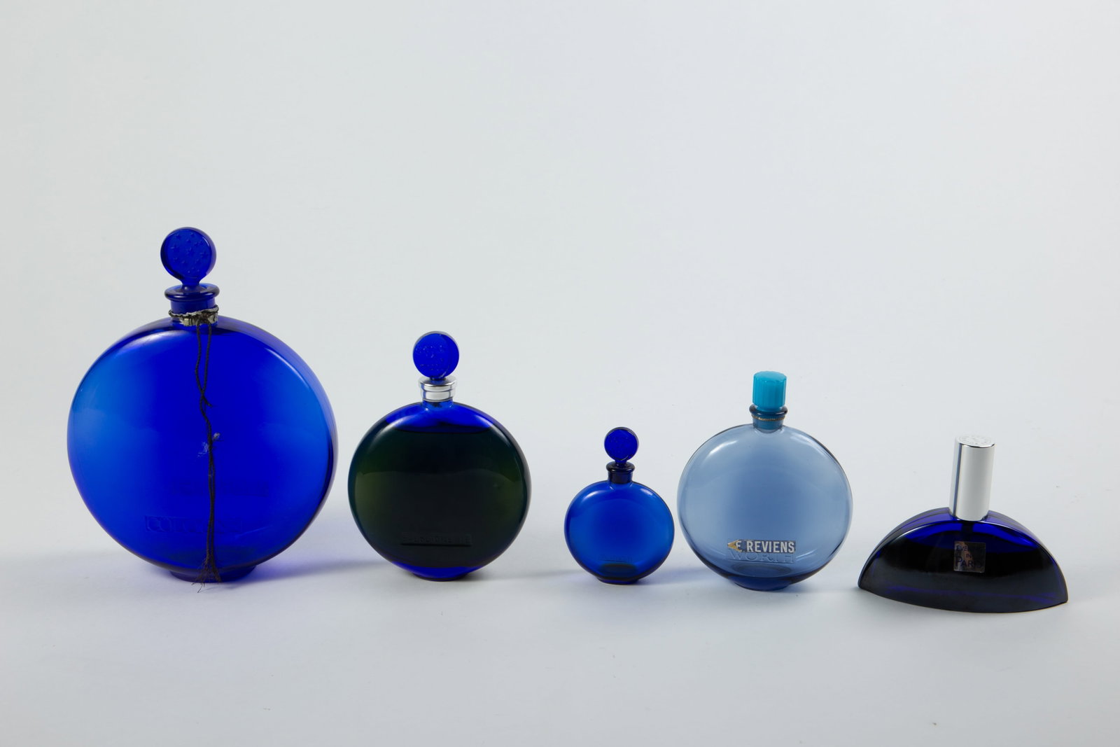 Lot of 5 French Blue Perfume Bottles- R. Lalique.: Two of these still have fragrance inside. One is Evening in Paris, and the other is Worth "Dans Le Nuit". Dans Le Nuit has a raised "R. Lalique" mark on the bottom. The three empty bottles include a s