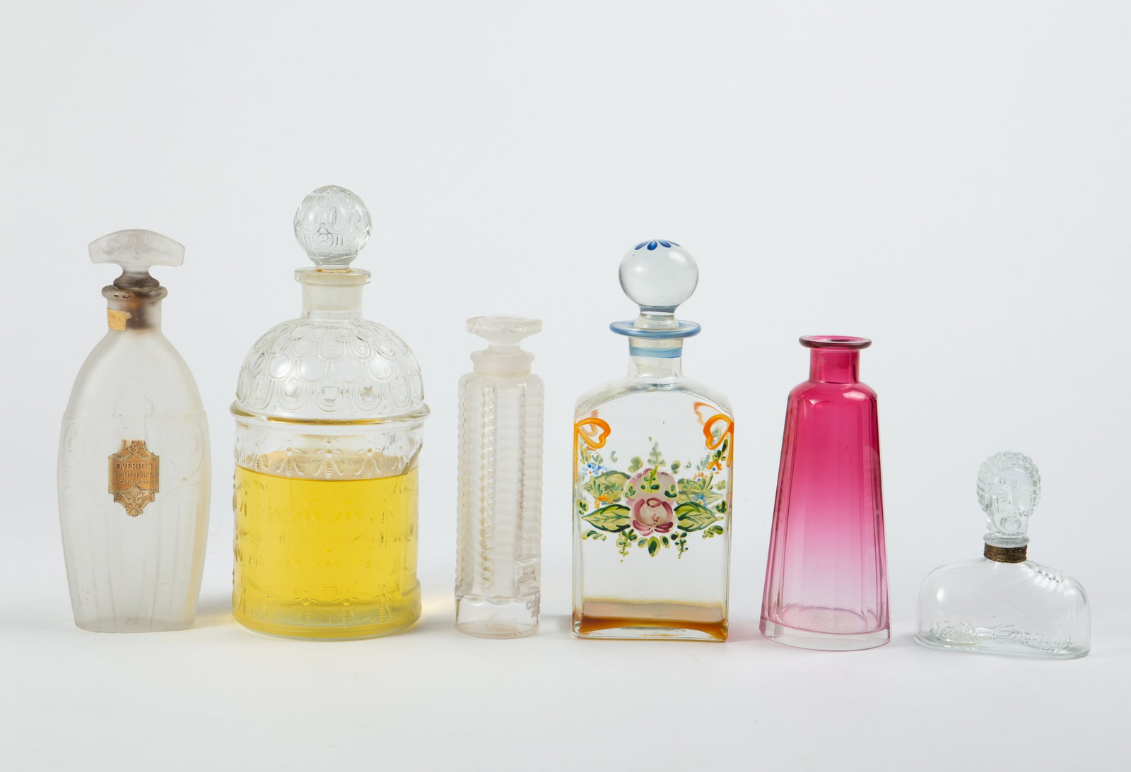 Lot of Perfume Bottles- Lalique, Hattie Carnegie.: This lot includes Guerlain, Lalique "Tzigane", Hattie Carnegie, Overton Perfumer, and more. Overall, the lot looks to be in good condition. The largest item measures 3 3/8" x 3 3/8" x 7 7/8". The smal