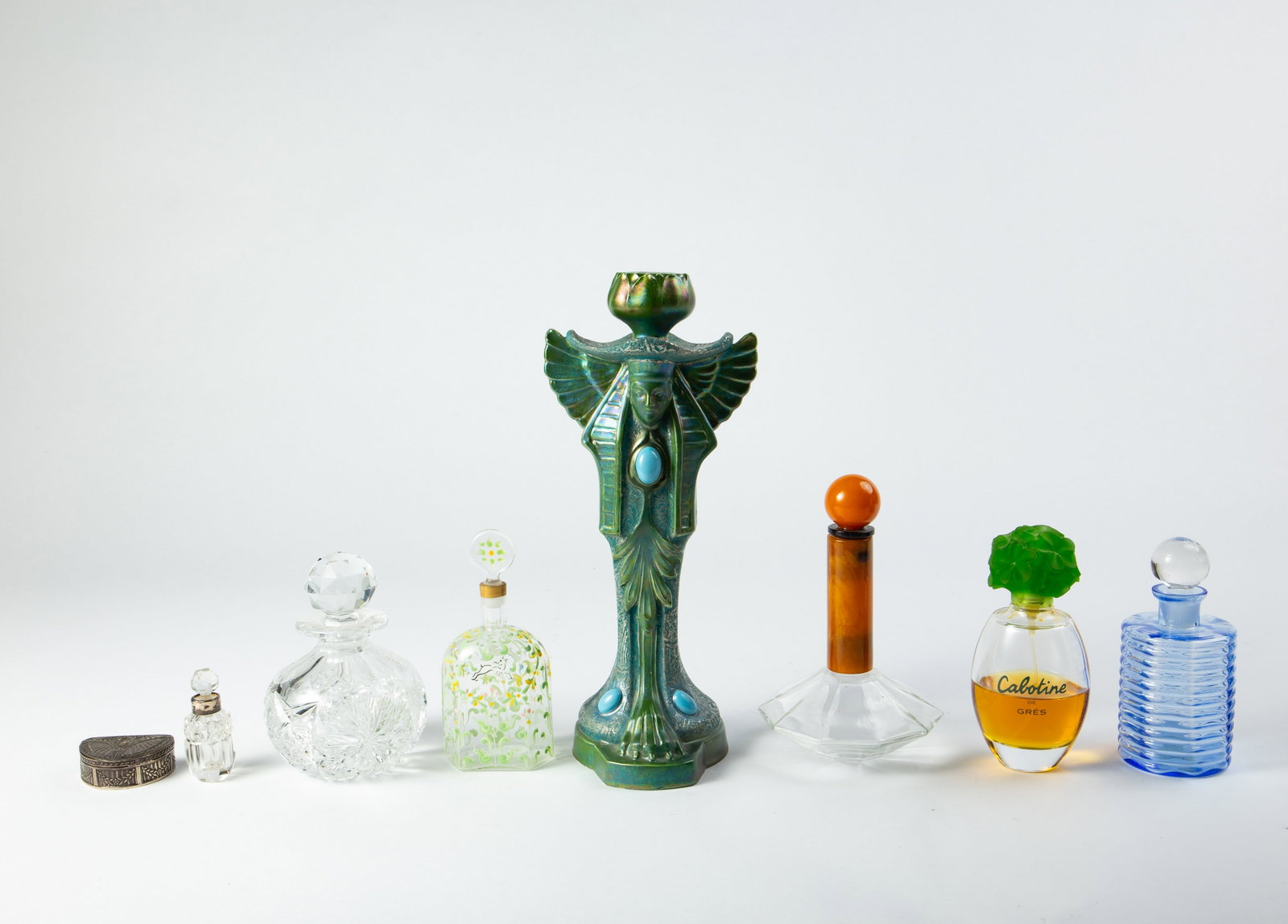 Lot of Perfume Bottles and Decorative Articles.: This lot includes assorted vintage perfume bottles, a figural Indian iridescent candlestick, a demilune pillbox, and more. Overall, the lot looks to be in good condition. The largest item measures 4 5
