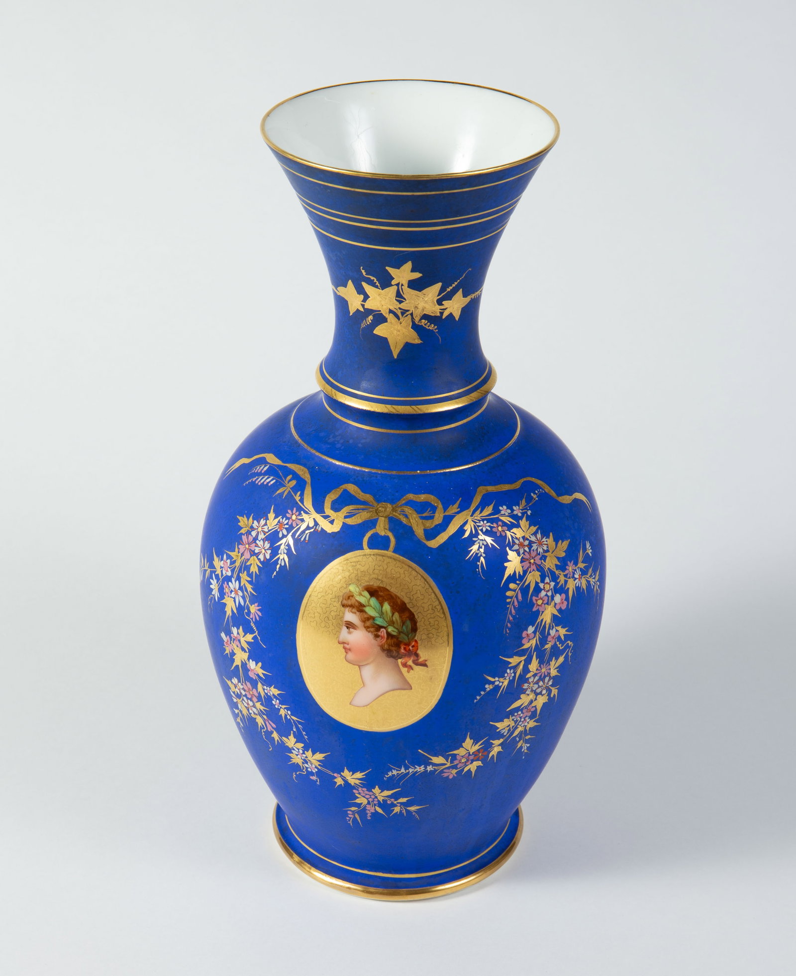 French Neoclassical Vase w/ Medallion Portrait.: This blue vase is decorated with painted flowers, gold colored bands, and a portrait of a youth wearing a laurel wreath. Overall, it looks to be in nice cosmetic condition. It measures 6 1/2" x 6