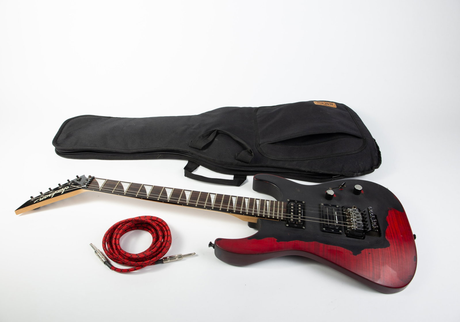 Jackson Electric Guitar with Case.: This high-performance instrument is popular among Metal musicians for its aggressive and crisp output. The guitar has parts by Bill Lawrence, Duncan, and Floyd Rose. It has mother of pearl details