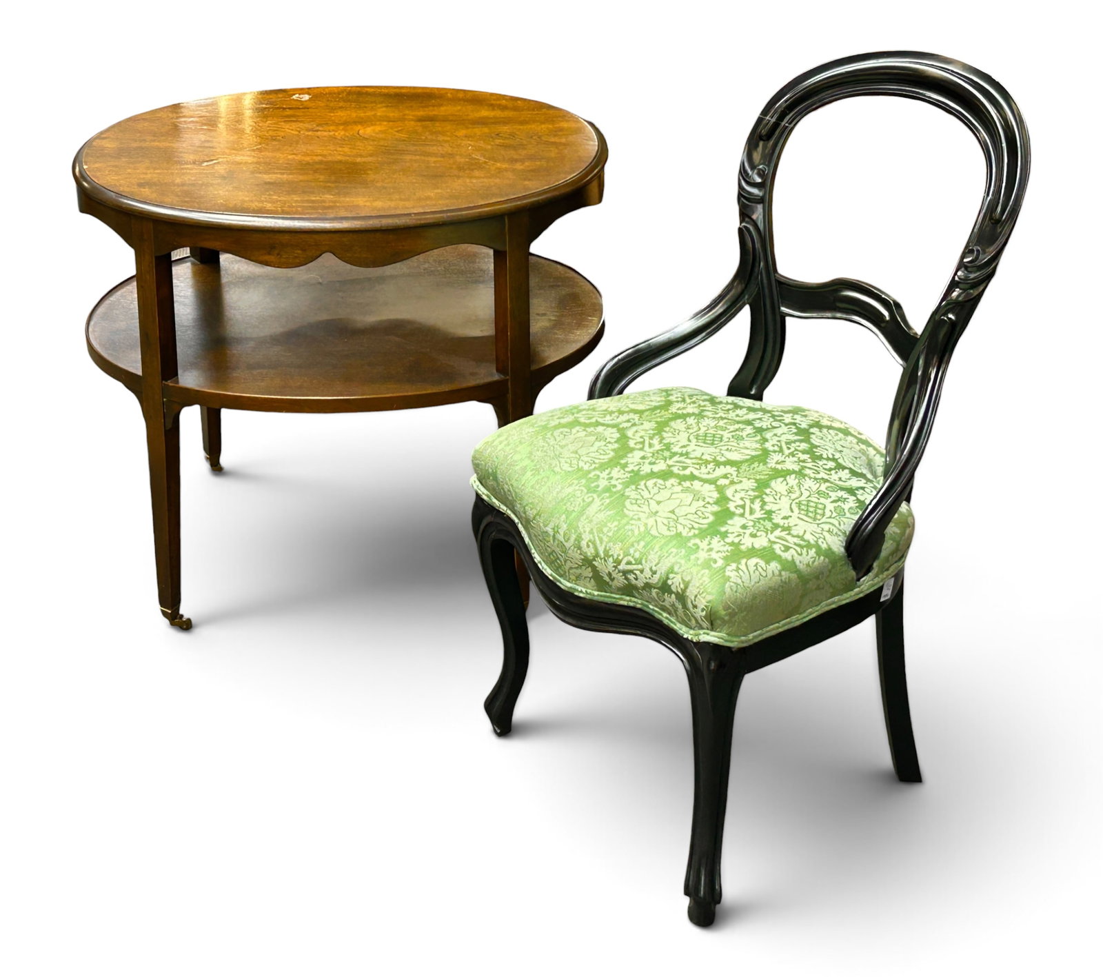 Two-Tier Table & Victorian Chair.: The two-tier table is made of walnut, with a scalloped apron, lower storage shelf, straight legs, and brass casters. The chair has a balloon back and floral upholstery. Both pieces are in good overall