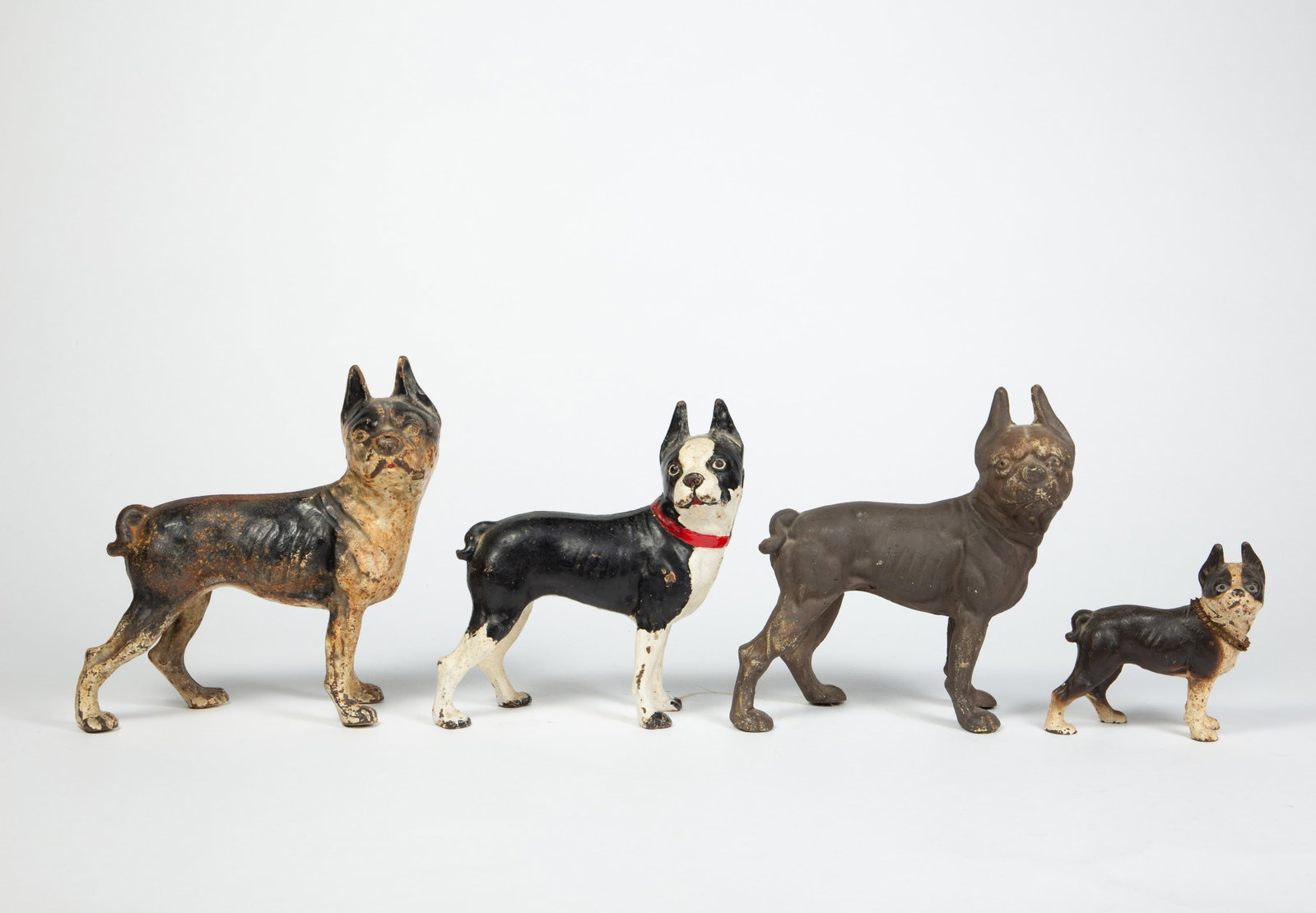 Lot of 4 Boston Terrier Cast Iron Doorstops.: There are some signs of surface wear, but overall, this lot still presents well. The largest dog measures 9 1/8" x 4 1/4" x 9 3/4". The smallest dog measures 5 1/2" x 2 5/8" x 5 1/2". In-house shippin