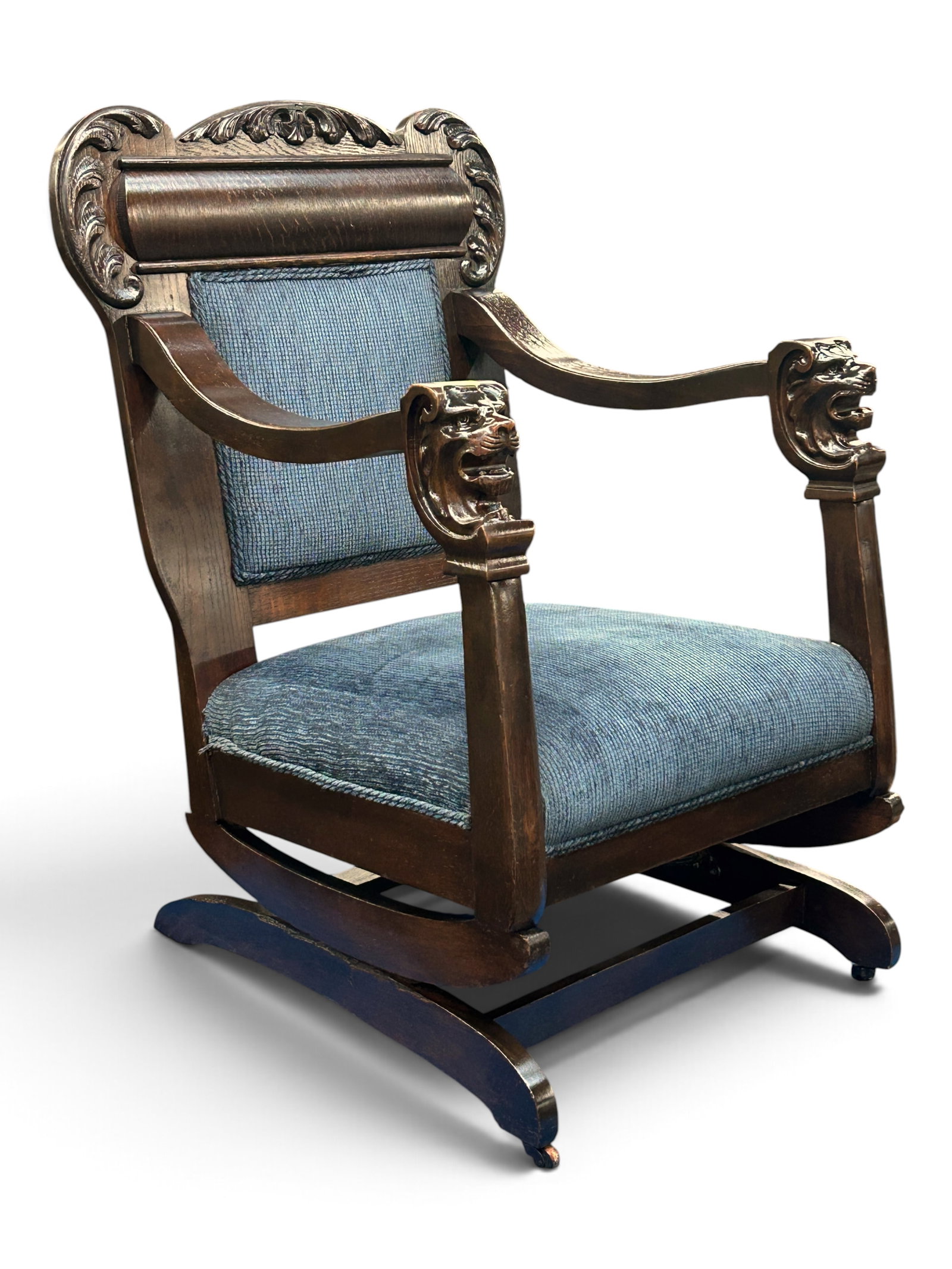 Antique Carved Platform Rocking Chair w/ Lions.: This dark oak rocker has carved lion armrests, a carved backrest, blue upholstery, and front casters. It is in great overall condition, with some minor wear. It measures 25 1/2" wide, 23" deep, and 38
