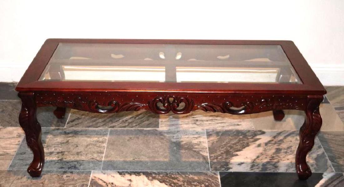 Mahigany coffee table glass top: Rich Mahogany tone carved Coffee Table with Glass Top w/ Carved Legs Approximate Size: 27" X 51" X 18"H