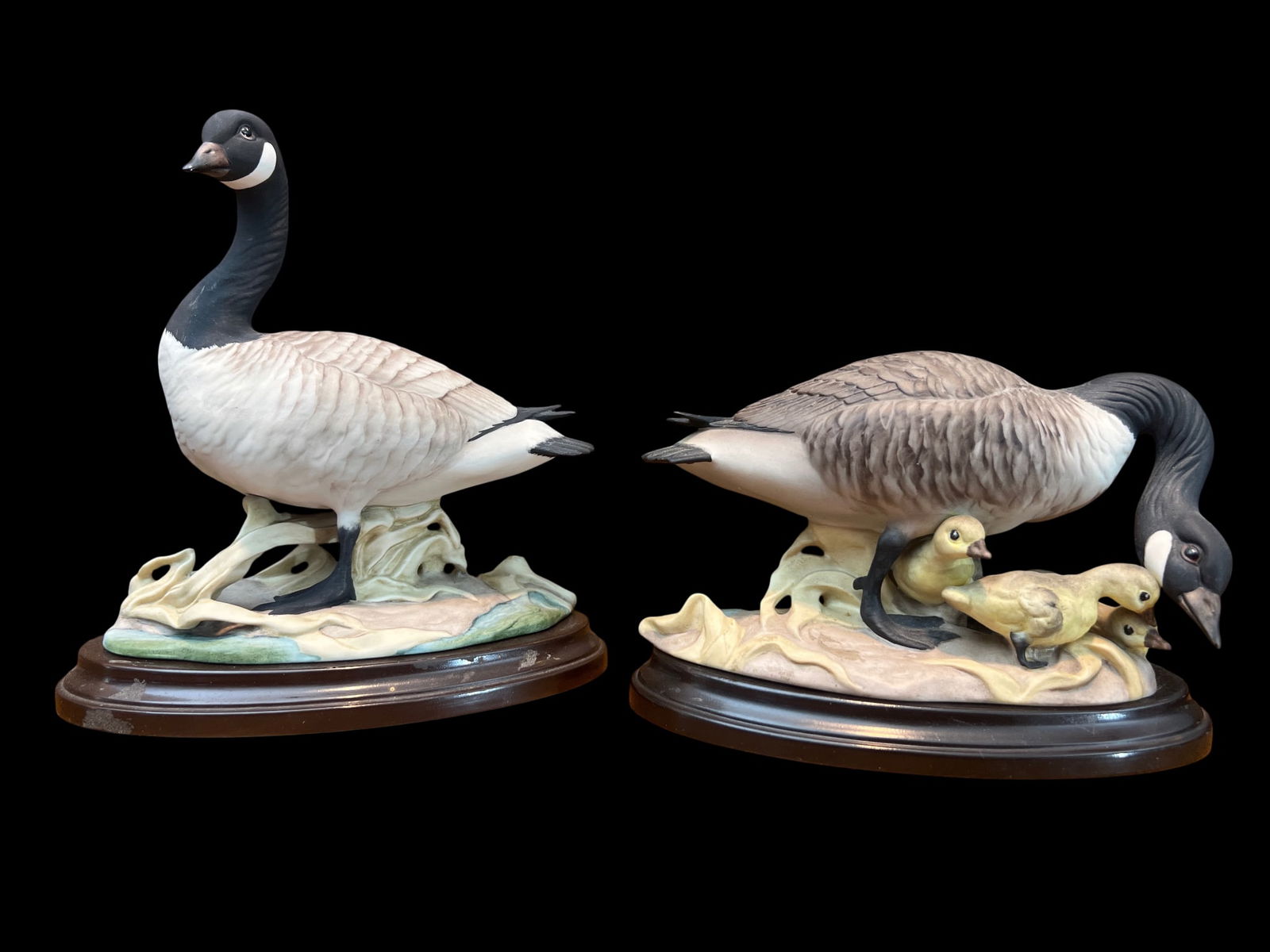 Pair of Boehm Porcelain Canada Geese Figurines, USA, 8": Pair of American porcelain Canada Geese by Boehm studio (Trenton, NJ). One upright gander, one goose with goslings. Bisque finish, hand-painted plumage (black head/neck, white cheek patch, brown-gray