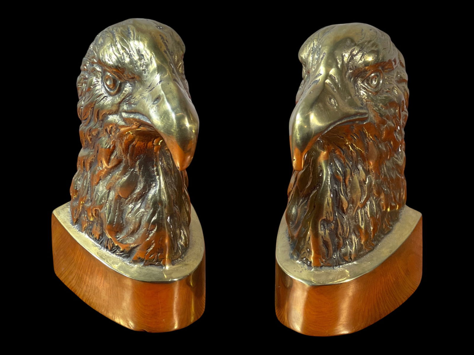 Pair of Korean Solid Brass Eagle-Head Bookends, Late 20th Century, 9" H: A decorative late-20th-century pair of solid brass bookends, hand-finished in Korea, modeled as stylized raptor/eagle heads with deep relief featherwork. Each bookend presents a forward-facing avian p