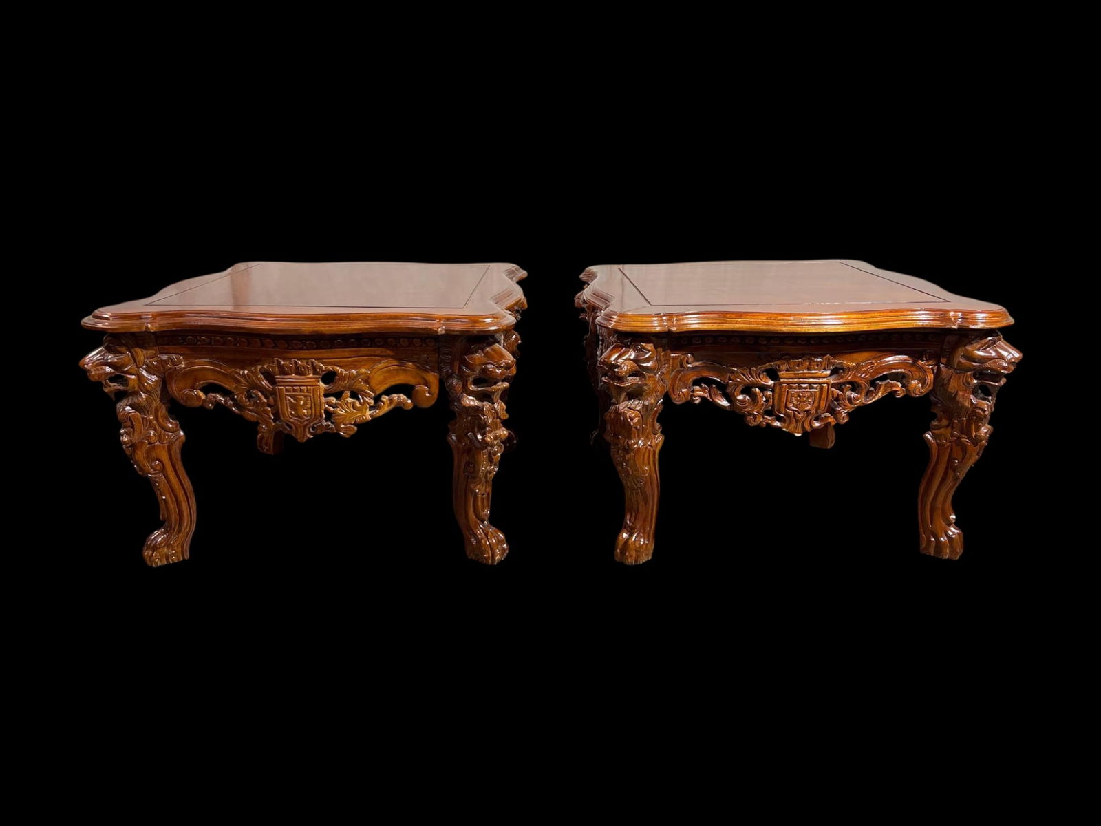 Pair of Renaissance Revival Hand Carved Walnut Occasional Tables with Lion Masks and Heraldic Crest: A substantial pair of Renaissance Revival mahogany carved walnut occasional tables, executed in an emphatically sculptural, architectural manner and conceived as companion pieces. Each presents a shap