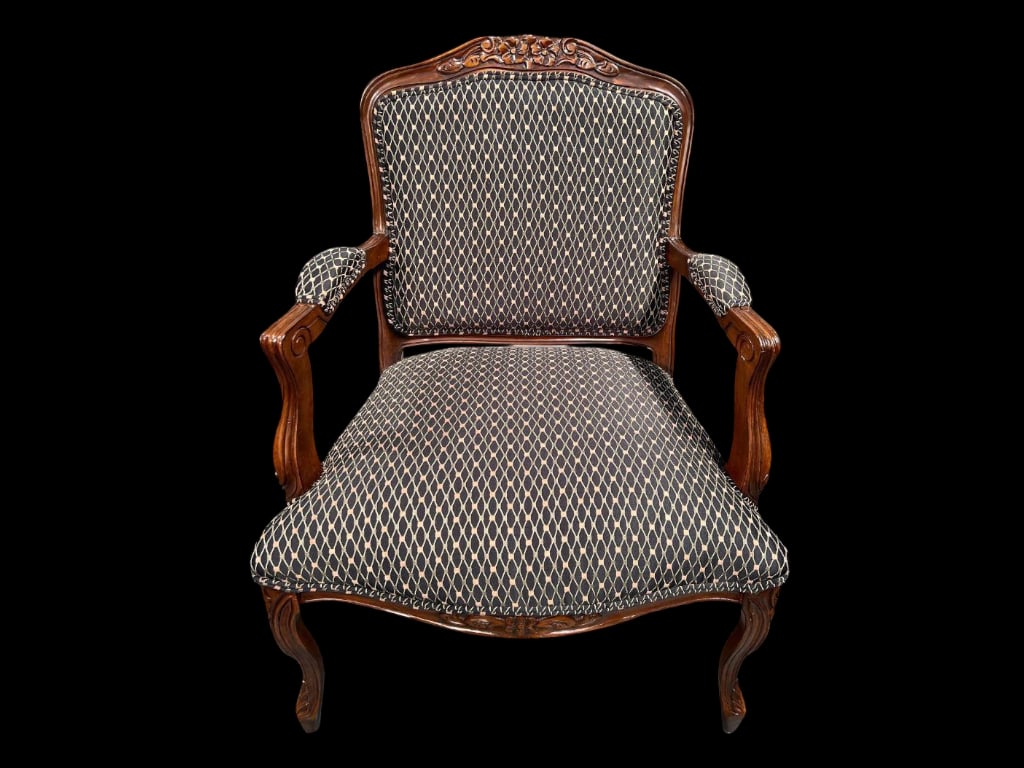 Italian Carved Wood Upholstered Armchair with Patterned Fabric: This Italian armchair features a wooden frame with intricate floral carvings on the crest rail. The chair is upholstered in a black fabric patterned with light-colored geometric shapes, covering the