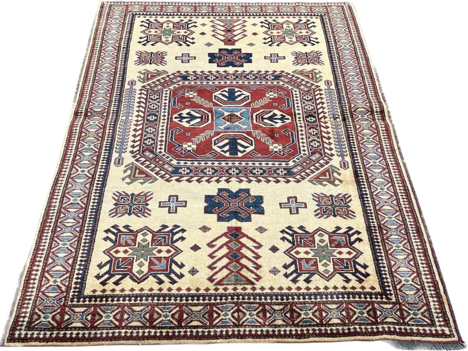 Rug Kazak Design Hand-Knotted Wool Area Rug, 4'10" x 6'5": Kazak design area rug with a bold geometric layout, featuring a large central medallion, stepped motifs, and multiple guard borders in ivory, brick red, navy, light blue, and soft green. The attached 