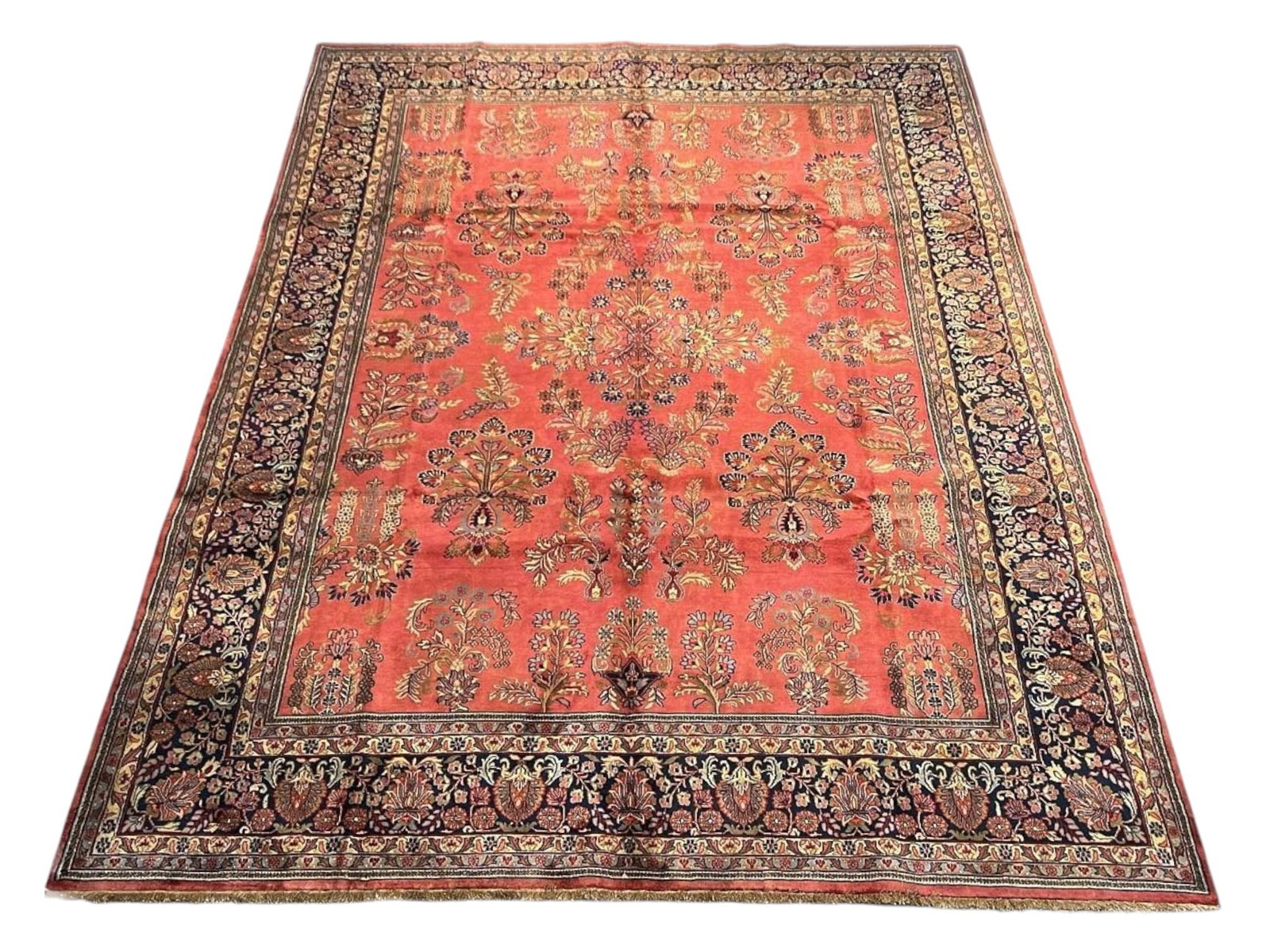 $9,675 - Detached Floral Carpet, Sarouk Design, Hand-Knotted Wool, 9'1" x 11'11": $9,675. A warm salmon-red field is set with detached floral sprays and palmettes in navy, gold and cream, each motif floating free rather than joined by vine, beneath a deep navy border of linked