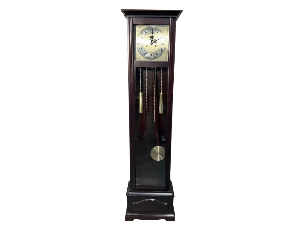 Grandfather Clock with Brass Pendulum and Roman Numerals Dial: This tall grandfather clock features a wooden case with a dark finish and a glass door showcasing the brass pendulum and weights suspended by chains. The clock face is square with intricate