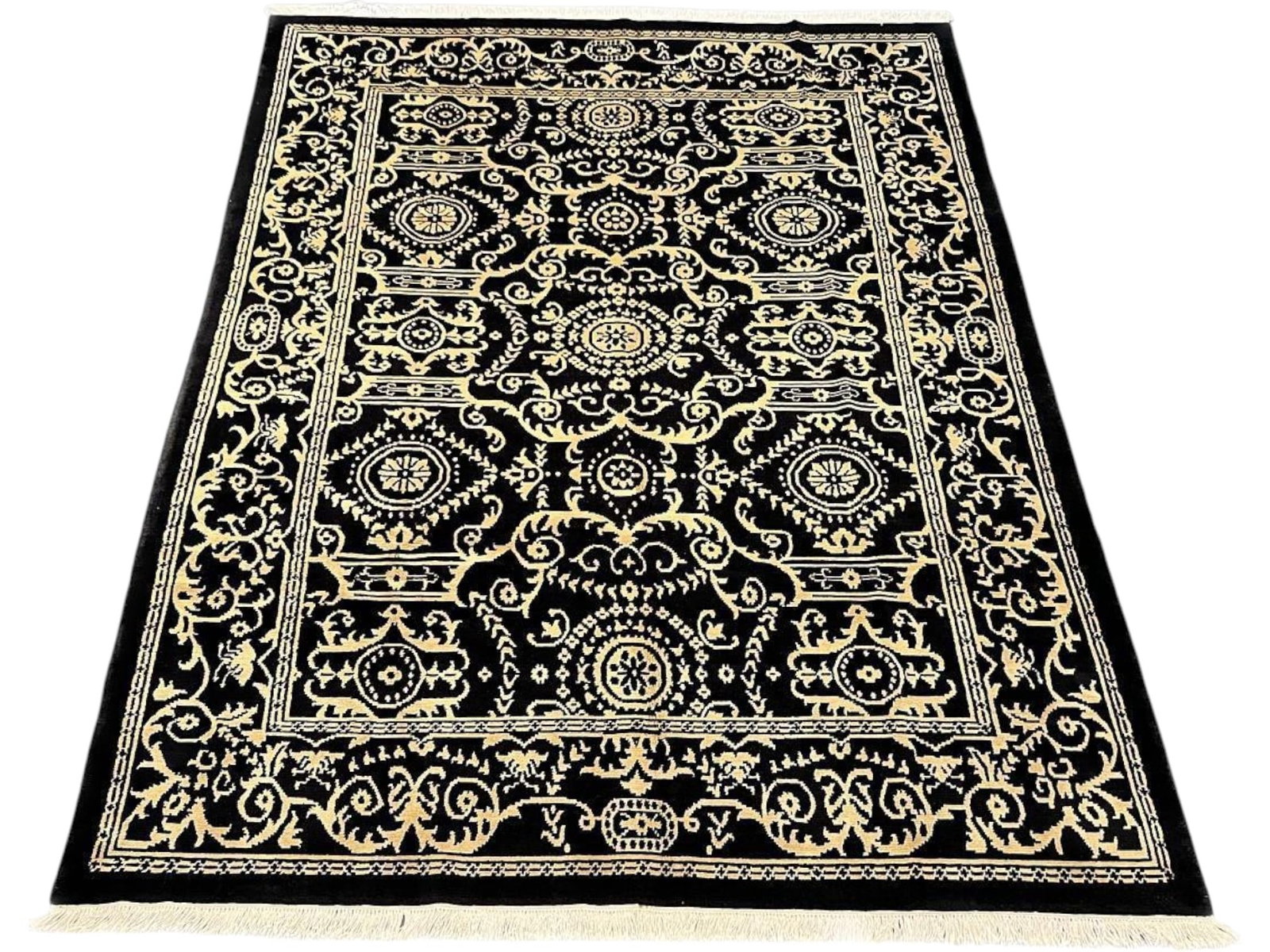 $6,230 - Onyx and Ivory Panel Carpet, Tibetan Design, Hand-Knotted Wool, 7'11" x 10'3": $6,230. High contrast governs the composition: an inky black ground carries an ordered grid of ivory rosettes, star medallions and interlocking bracket panels, answered by a wide border of bold scroll