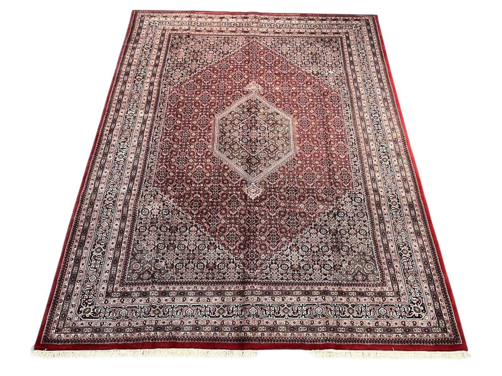 $7,525 - Room-Size Herati Carpet, Bidjar Design, Hand-Knotted Wool, 8'6" x 11'7": $7,525. A deep burgundy-red field is worked in a minutely repeated herati lattice, centred on an ivory hexagonal medallion, with multiple ornate borders in navy, beige and soft blue. Carpets built to 