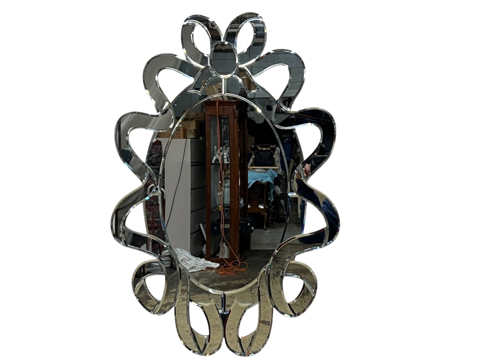 Mirror wall accent with scrollwork beveled frame, 20 x 30: Mirror wall accent featuring an elongated central looking glass framed by a highly decorative surround of openwork scrolling and petal like forms. The design combines curving silhouette with a faceted