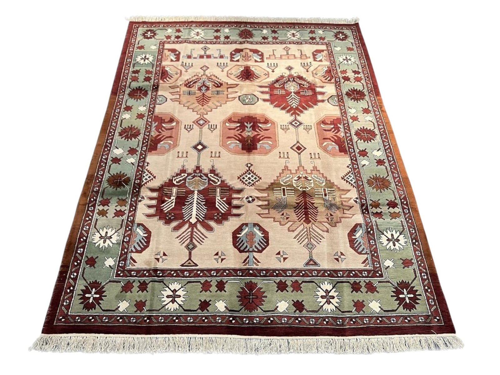 $5,425 - Sand Ground Geometric Carpet, Geometric Medallion Design, Hand-Knotted Wool, 8'10" x 12'0": $5,425. A pale sand field carries bold geometric medallions and stylised flowering vessels in brick red, teal and cream, with a sage green border punctuated by eight-point star rosettes and edged in
