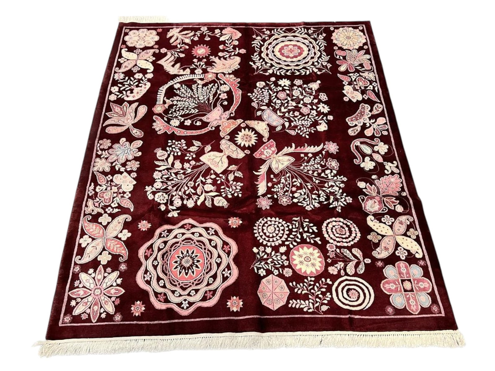 $4,180 - Suzani-Style Sampler Carpet with Butterfly Motifs, Hand-Knotted Wool, 8'2" x 10'0": $4,180. A deep burgundy ground is laid out as an embroidered sampler, each panel filled with a different device: rosette medallions, paisley ornament, flowering branches, a peacock within a roundel, a