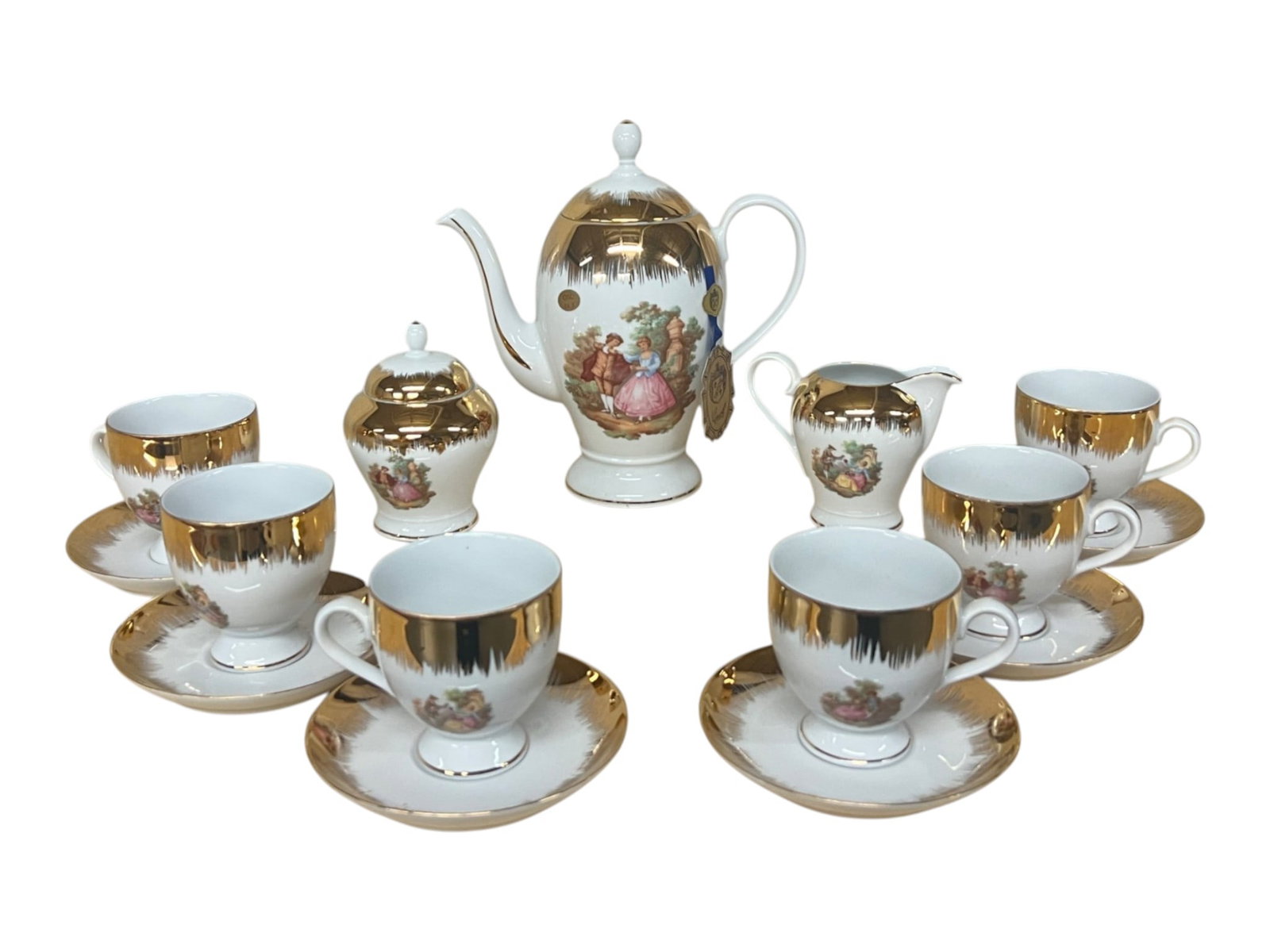 Italian Gilt Porcelain Coffee Service with Fragonard Courting Scenes, Bearing the Mark of DEPOS T. L: This fifteen piece coffee service pairs bright white porcelain with lavish 24 karat gold decoration applied in a dramatic downward flare, the gilding descending from each rim in fine radiating spikes 