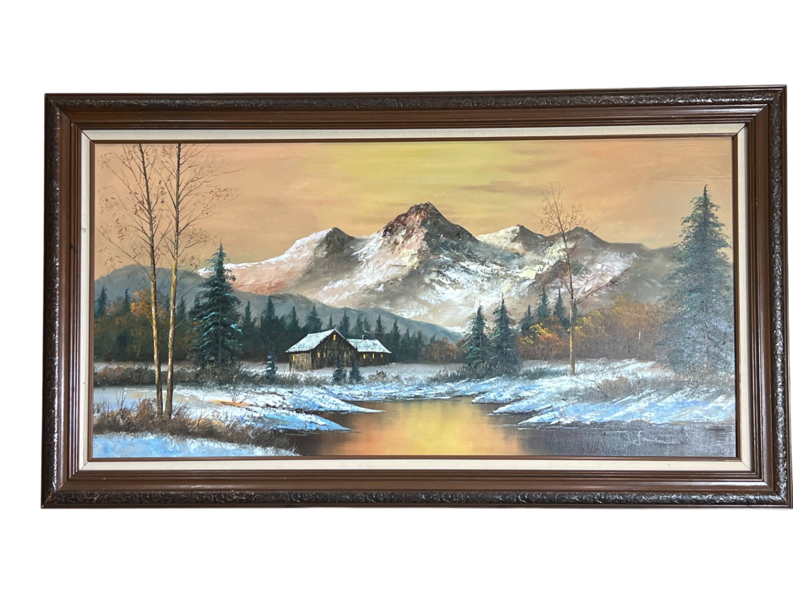 Garrison, Winter Mountain Landscape with Cabin, Oil on Canvas, Signed, Framed, 55 x 31": This panoramic winter landscape presents a snow covered valley beneath rising mountain peaks, painted in oil on canvas in a warm and atmospheric palette. The composition is built horizontally, carryin
