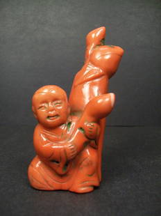 Red Coral Carved branch form boy and Peach: 红珊瑚枝条形童子送寿桃摆件：A Chinese red coral carved branch form boy and Peach. H: 11.3 cm, W: 5 cm, 151 grams