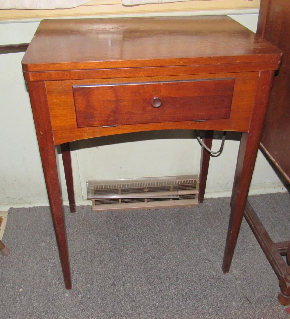 Vintage Singer Sewing Machine: Sewing Machine is loose in cabinet and cabinet has damage. Sewing machine is sold in untested condition. Cabinet is approx 17"x 23"