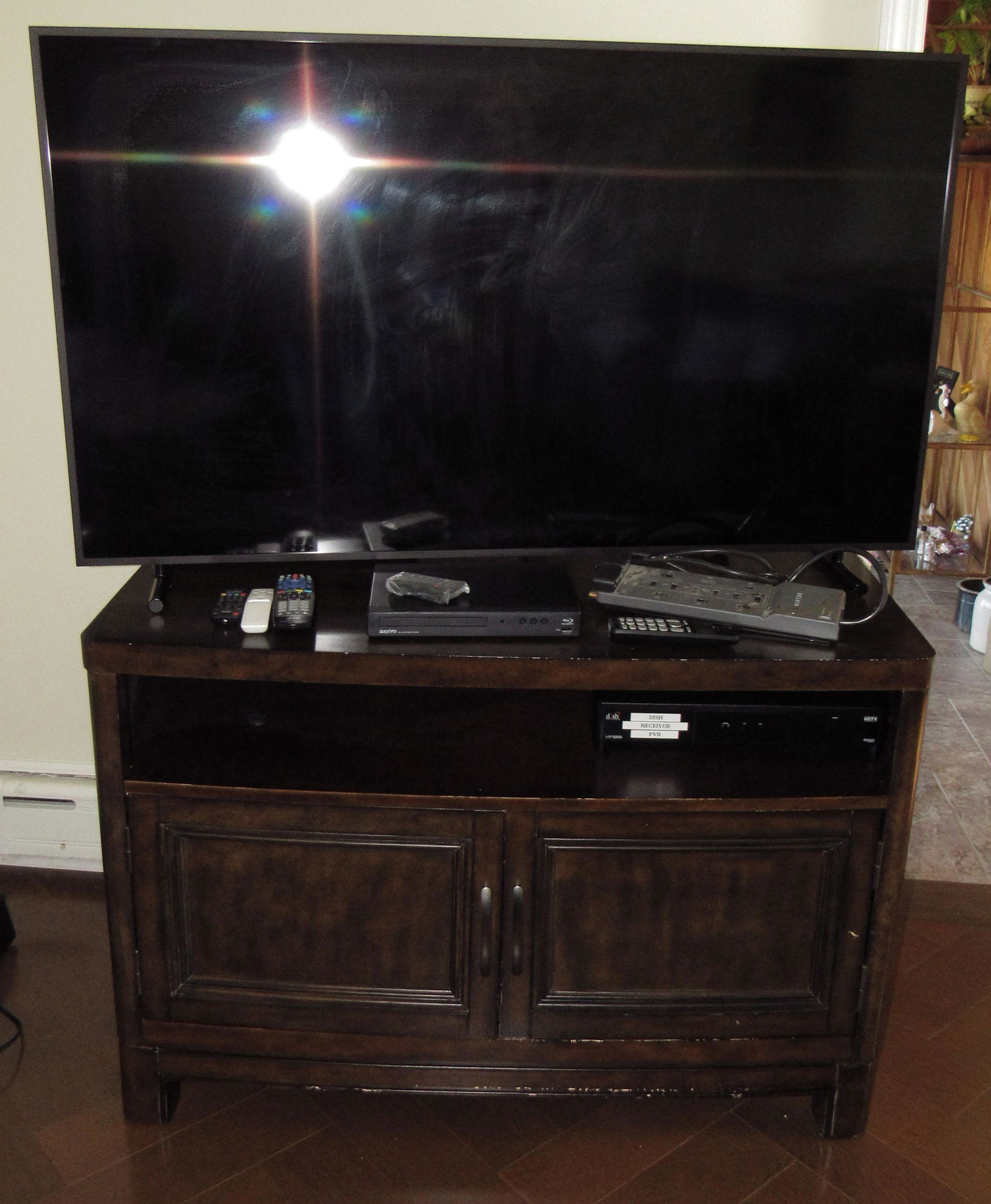 Samsung 55 inch Flat Screen TV With Cabinet: Lot includes TV, cabinet, and Items on top. Does not include movies in base