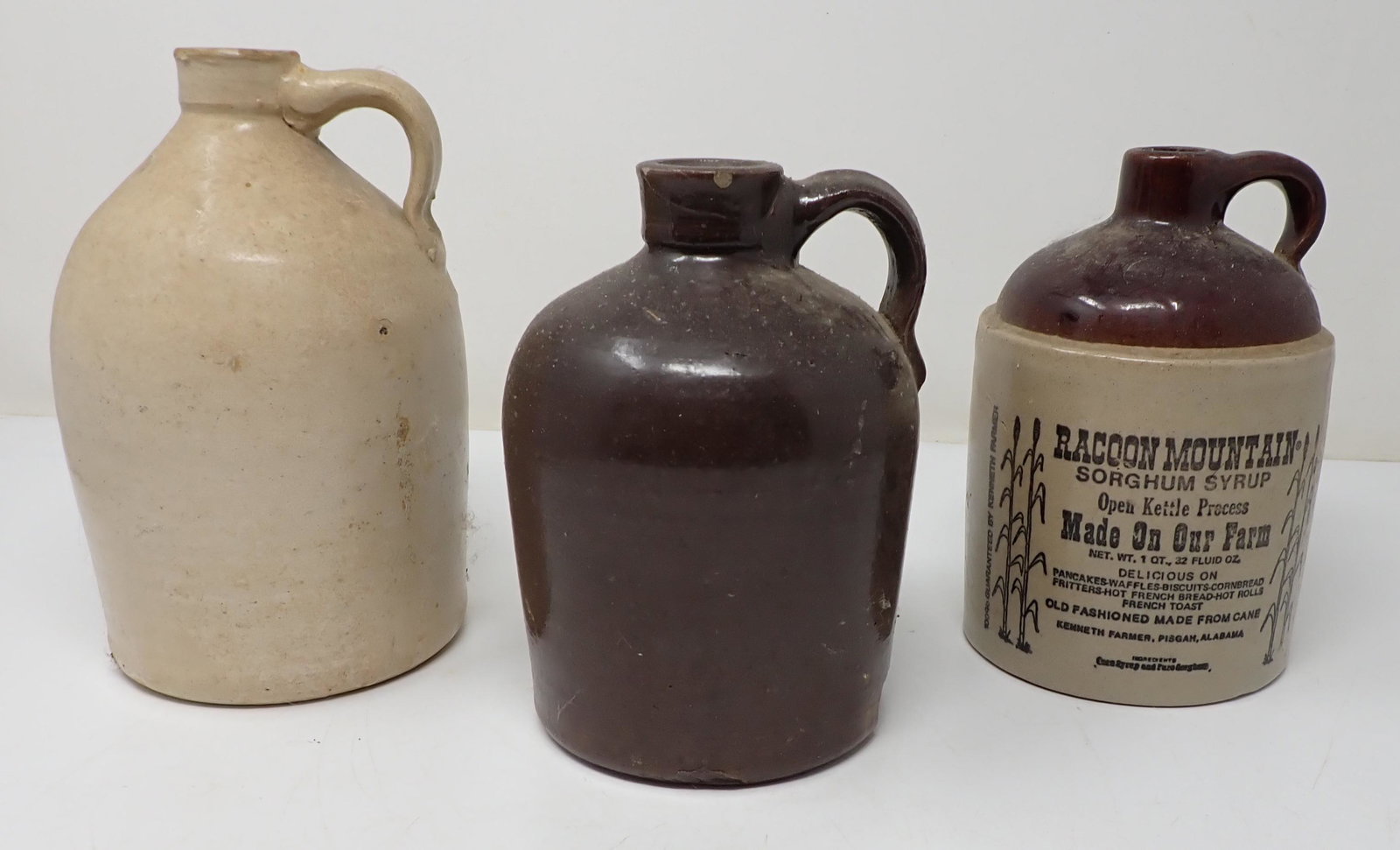 3 Stoneware Jugs Racoon Mountain Syrup: Largest is approx 8" tall