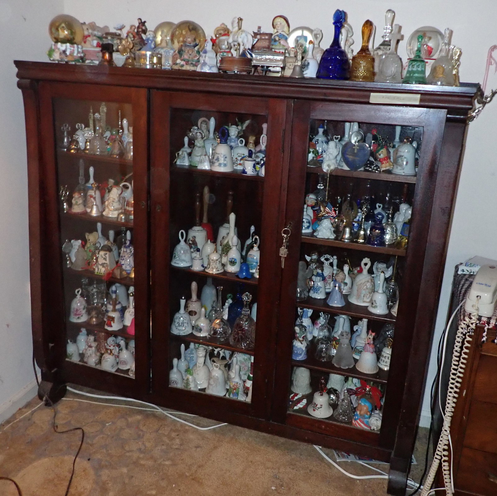 Large Bell Collection: Getting all pictured in and on bookcase. Includes some music boxes on top. Items must be removed before Noon !
