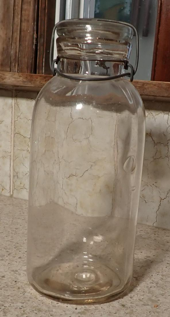 Fruit Jar w/ AC Smalley Lid: Approx 4 1/2" in diameter and 11" tall. Has large bubble in glass.